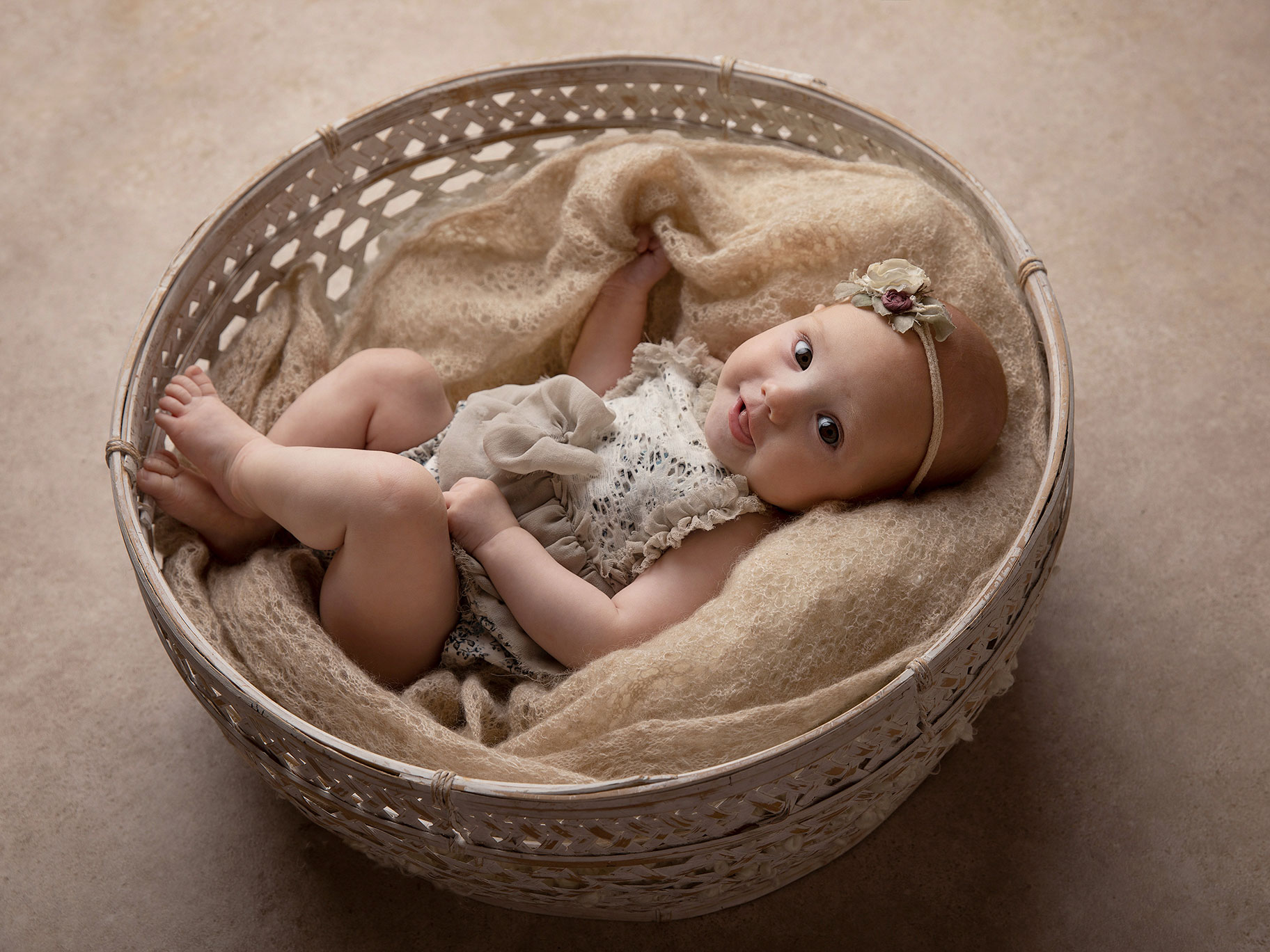 Busig baby blir fotograferad i en vit korg i Malmö.