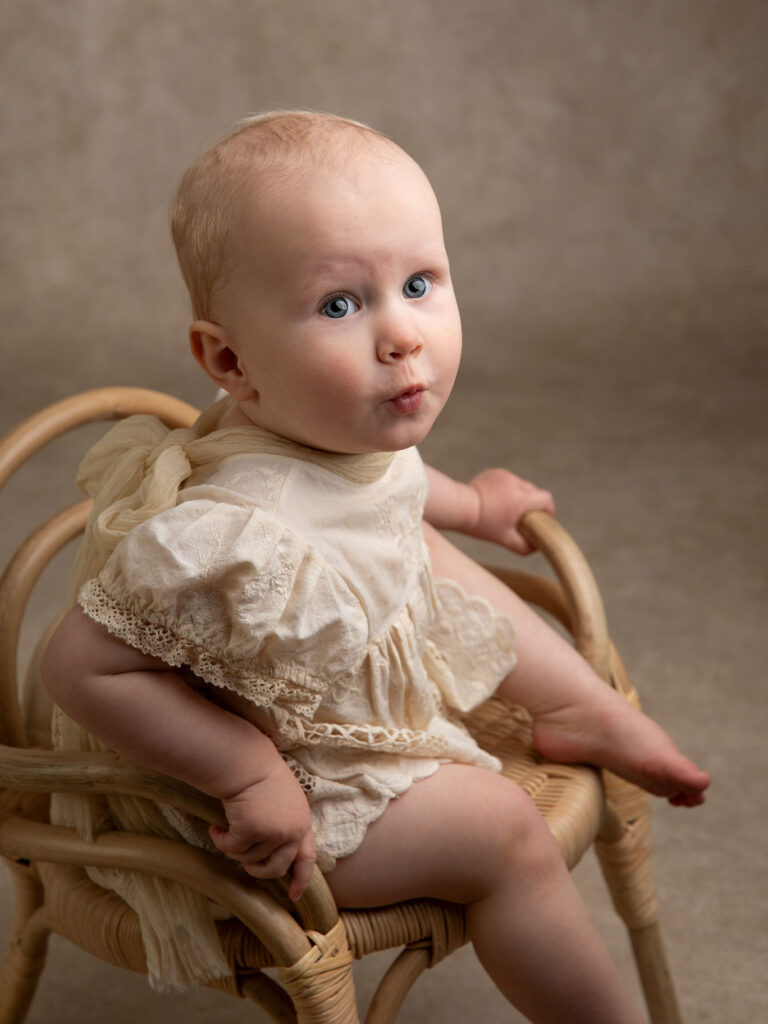 Babyflicka gör rolig min under en fotografering i en studio i Malmö.
