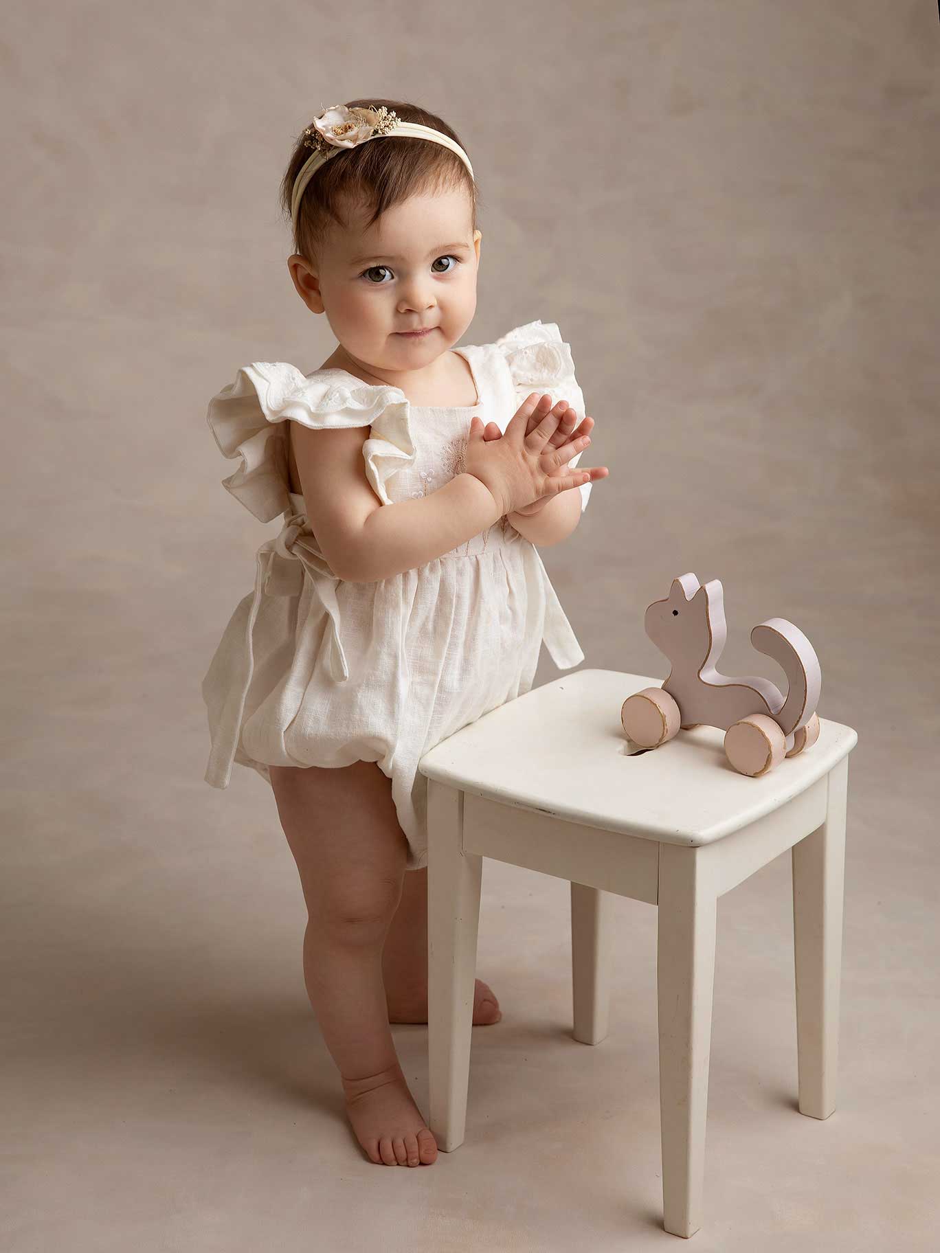 Liten flicka klappar händerna under en fotografering i fotografen Anna Arvidssons studio i Malmö.