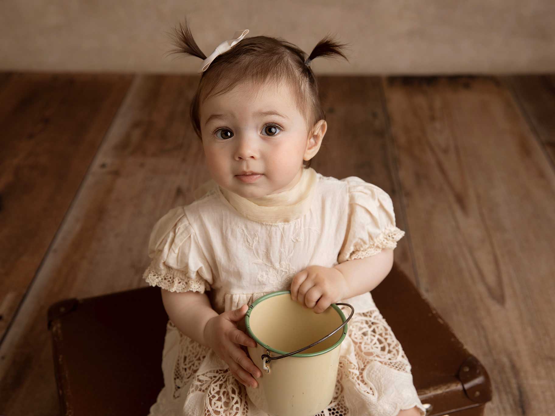 Liten flicka sitter på en resväska under en barnfotografering i Malmö med fotografen Anna Arvidsson.