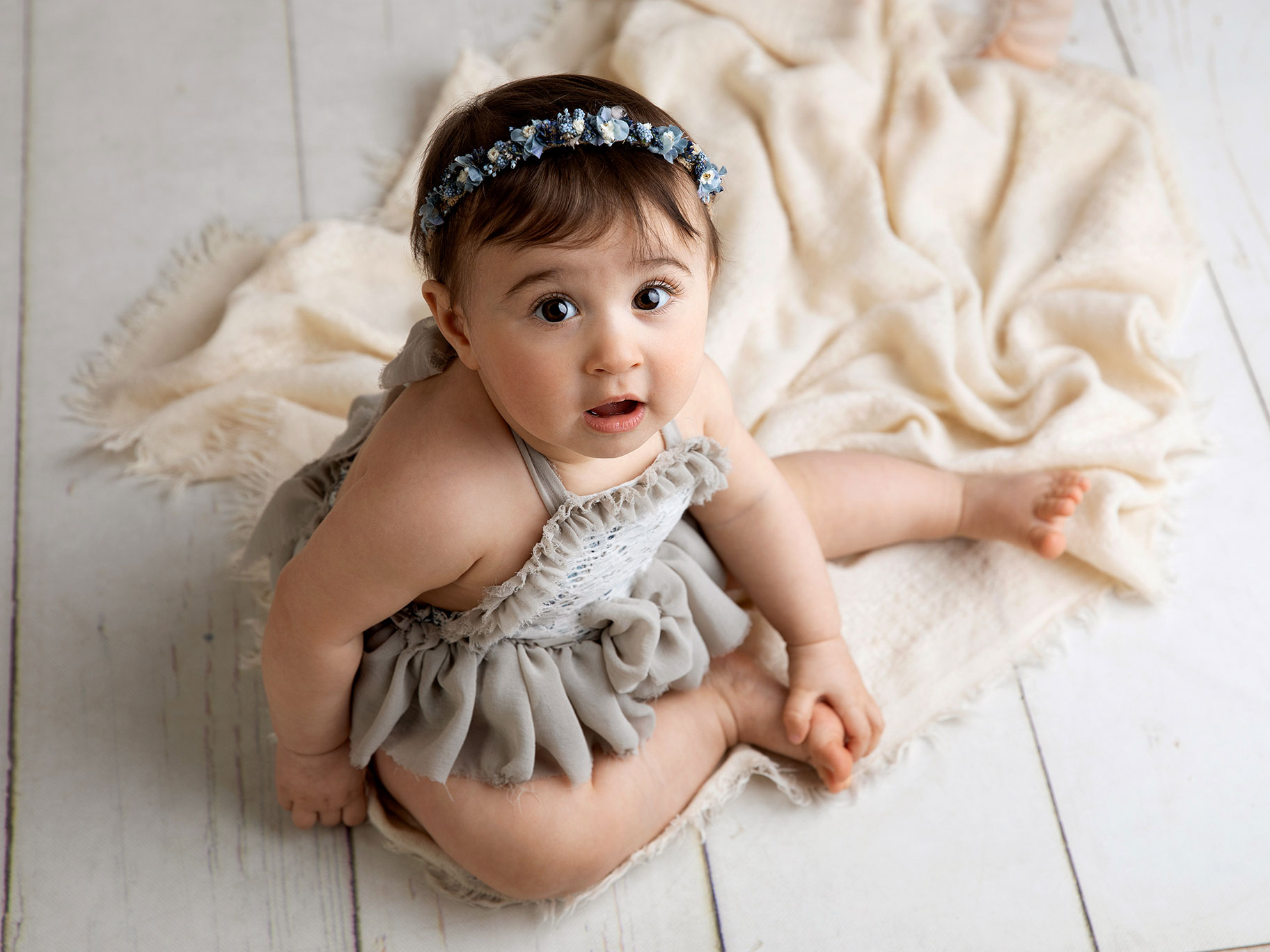 Liten flicka sitter på glovet under en barnfotografering i Malmö.