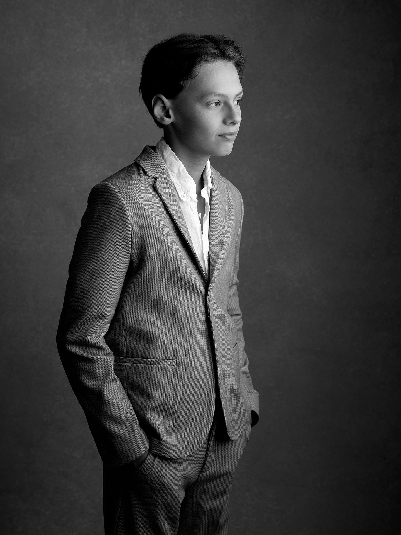 Svartvit bild på barn i eftertänksam pose, fotograferat i konstnärlig stil i Malmö.