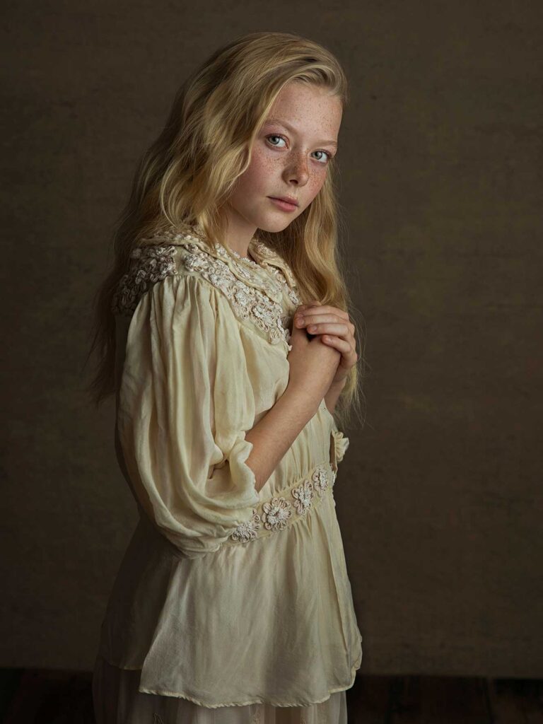 Barn i vintageinspirerad klädsel framför mörk bakgrund, fotograferat av Anna Arvidsson.