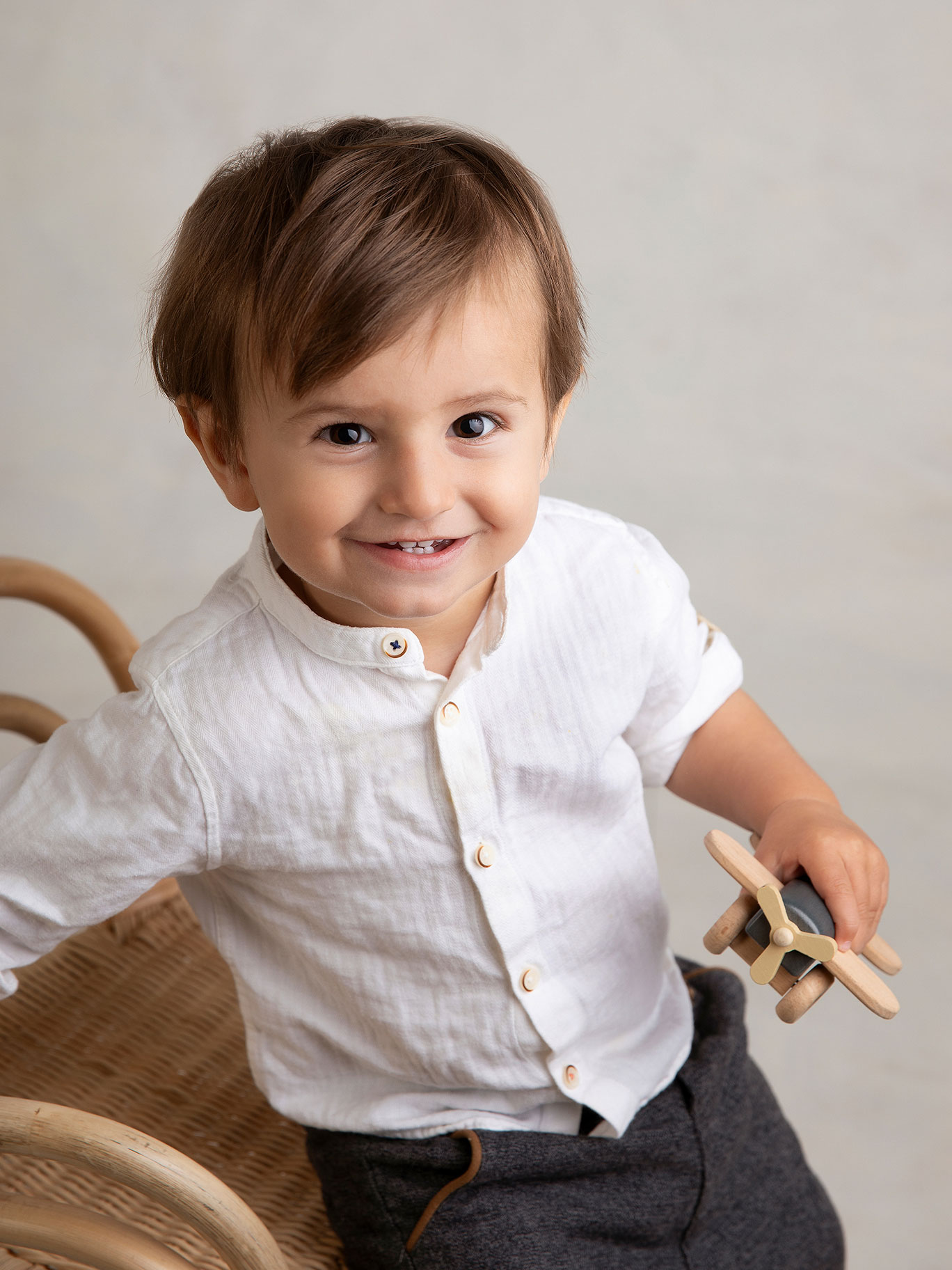 Pojke sitter och ler busigt mot kameran hos Fotograf Anna Arvidsson i studion i Malmö.