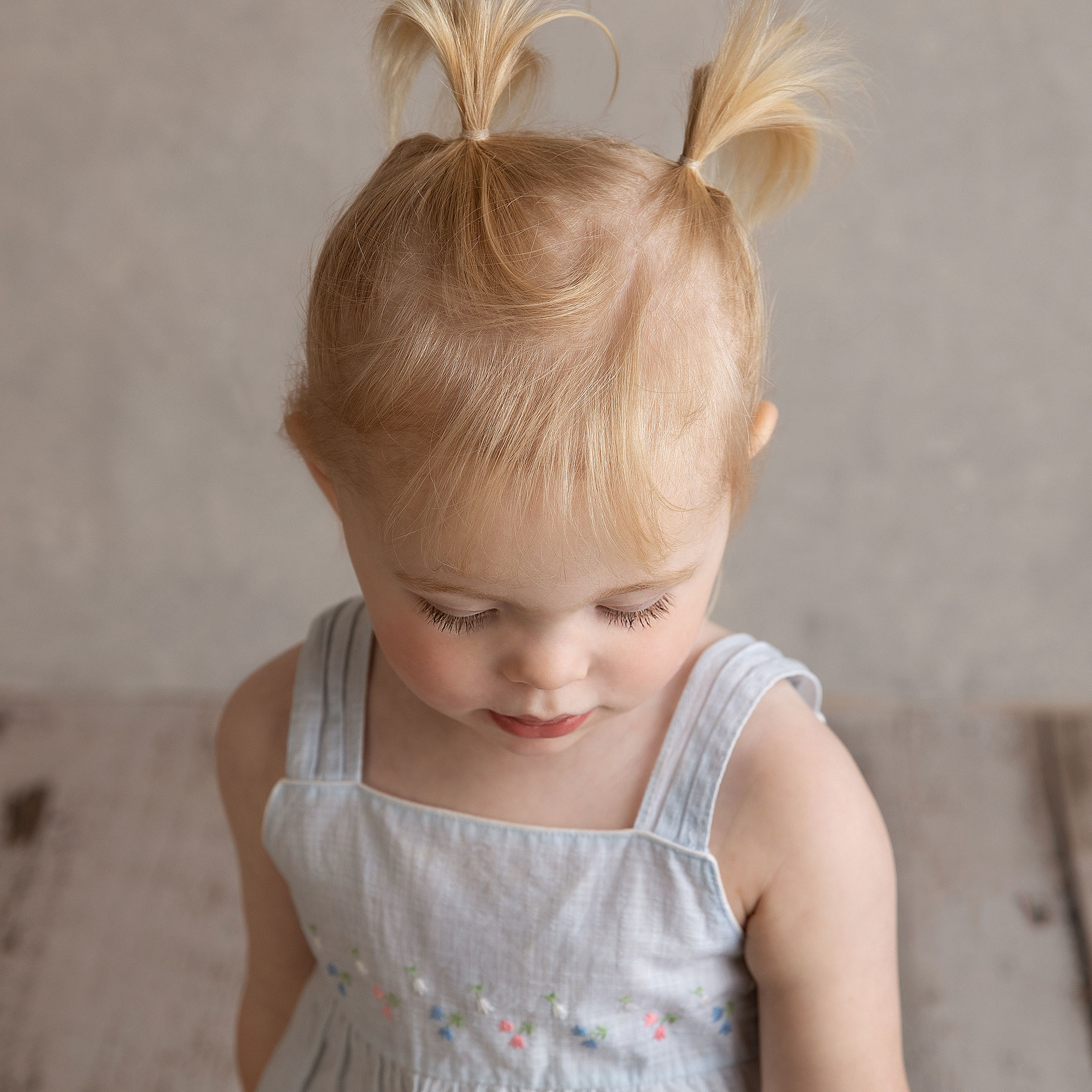 Liten flicka blir fotograferad när hon tittar ner av fotograf Anna Arvidsson i studion i Malmö.