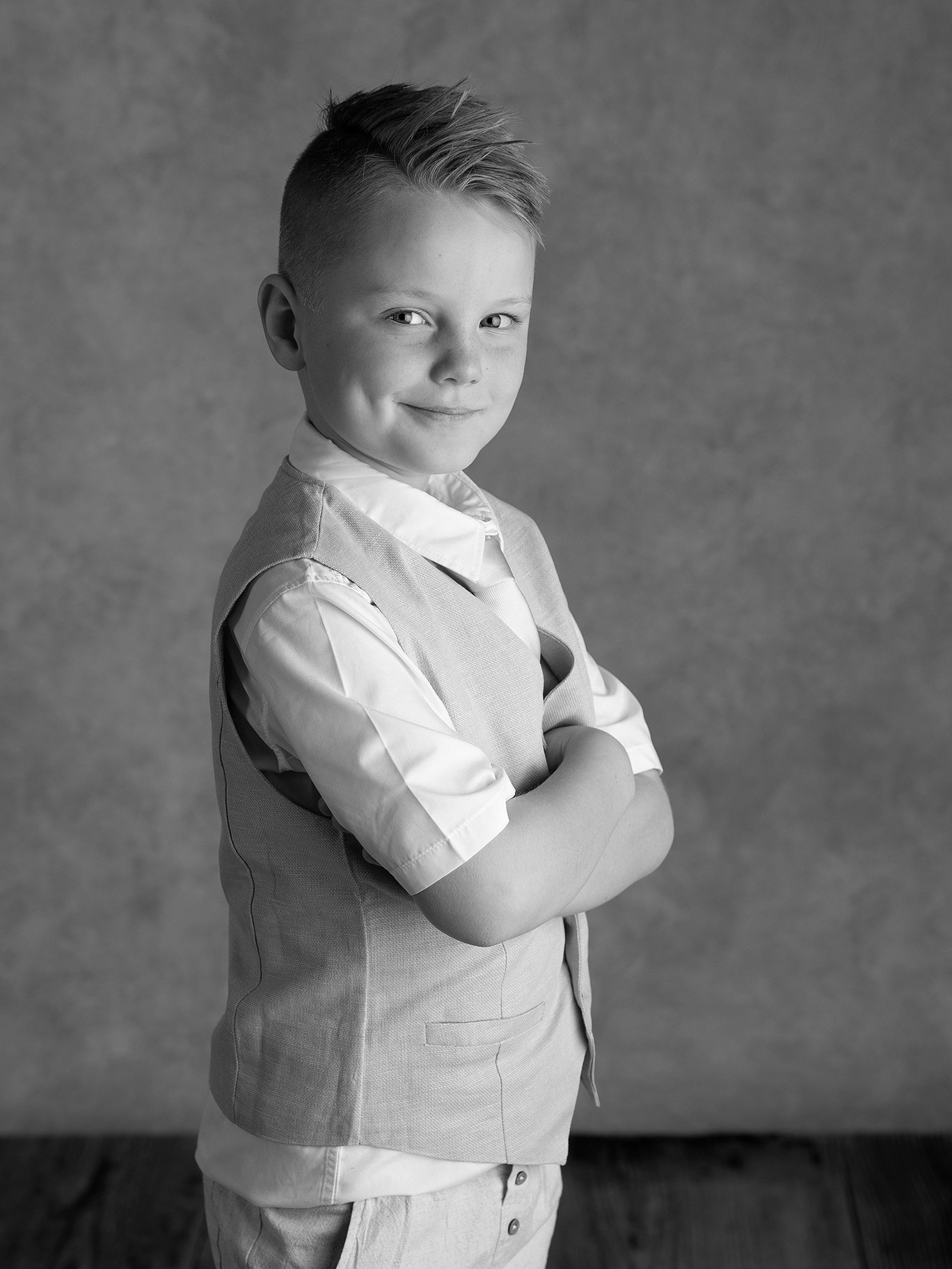 Pojke i väst under en barnfotografering i en studio i Skåne.