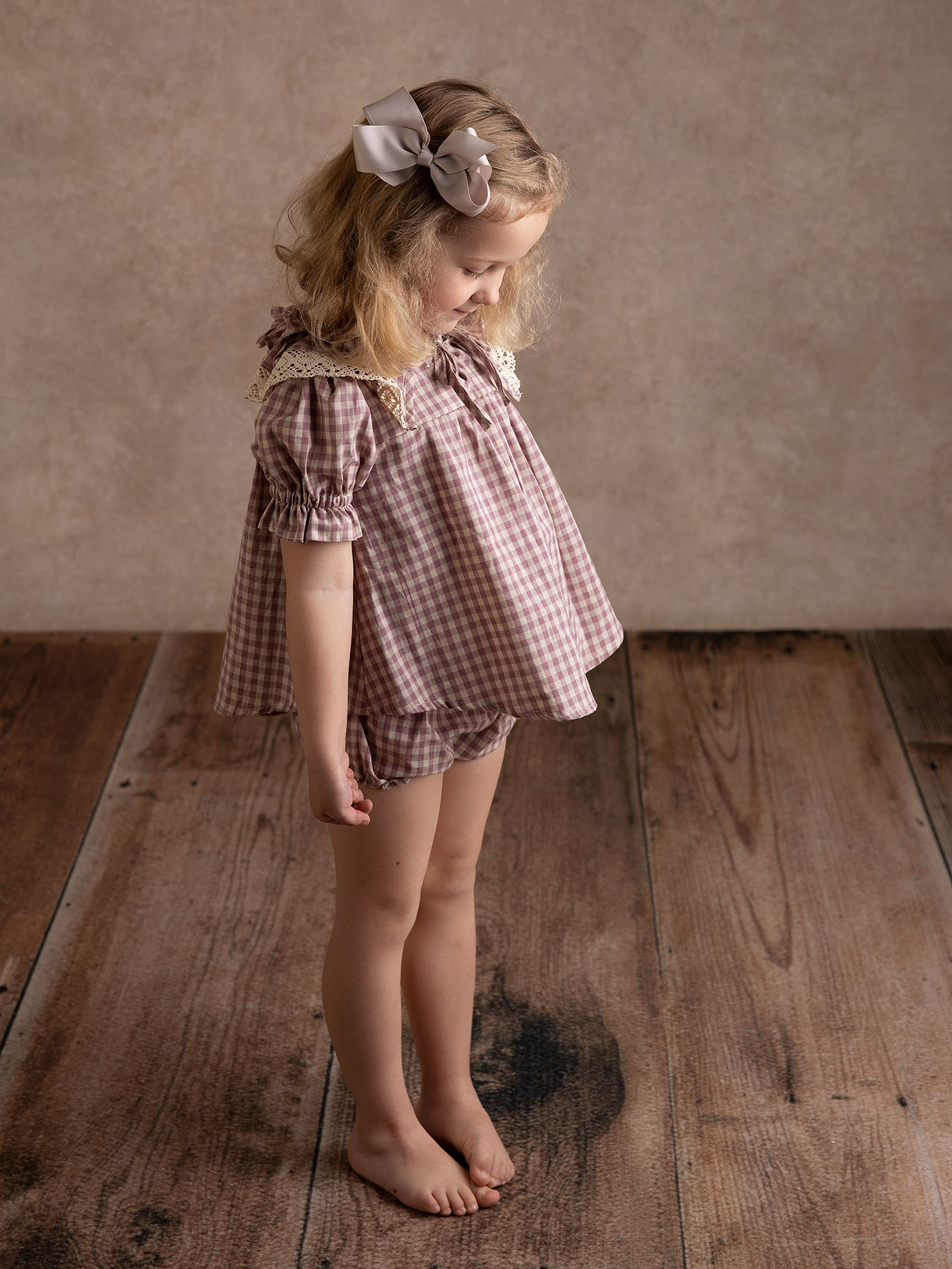 Svartvit bild på fliFlicka med rosett i håret verkar tycka om att bli fotograferad av Anna Arvidsson, familjefotograf i Malmö, Skåne.