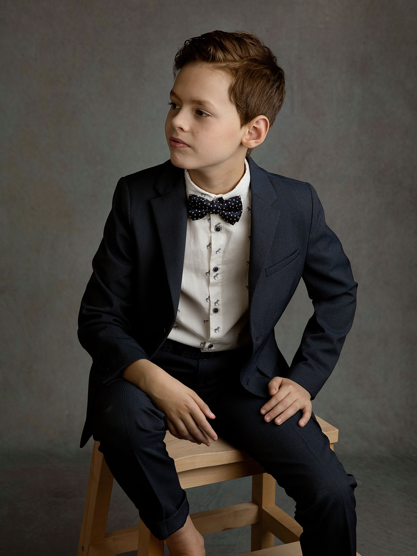 Pojke i kostym blir fotograferad av Anna Arvidsson i studion i Malmö.