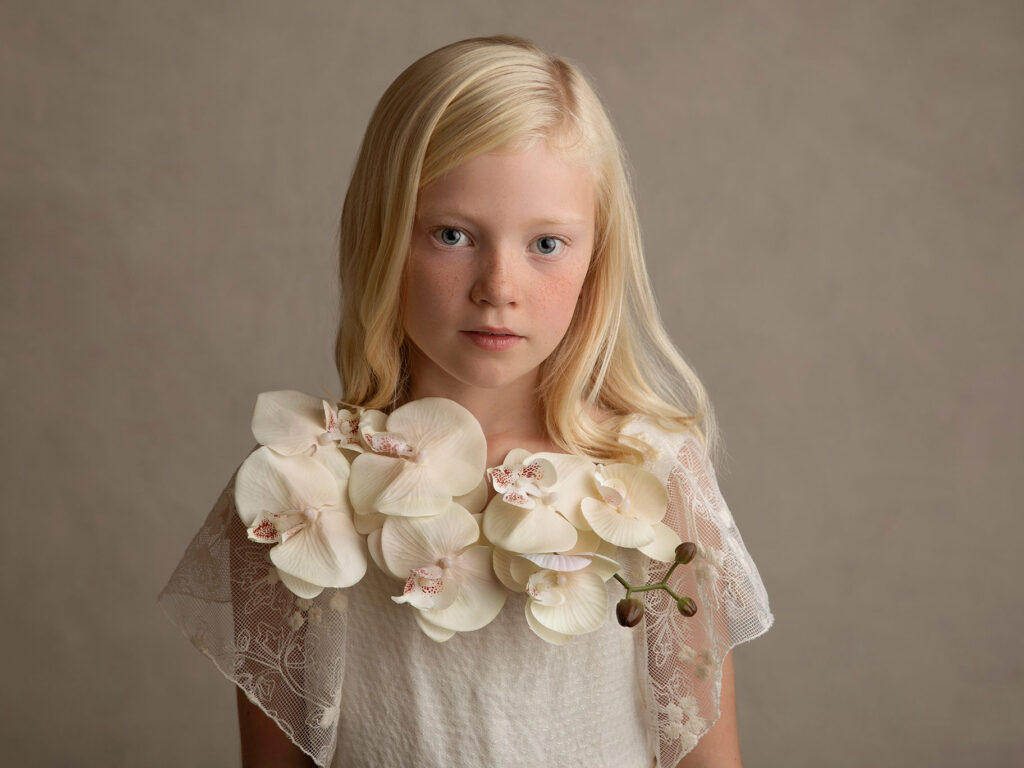 Barn med blommor runt halsen fotograferat av Anna Arvidsson.