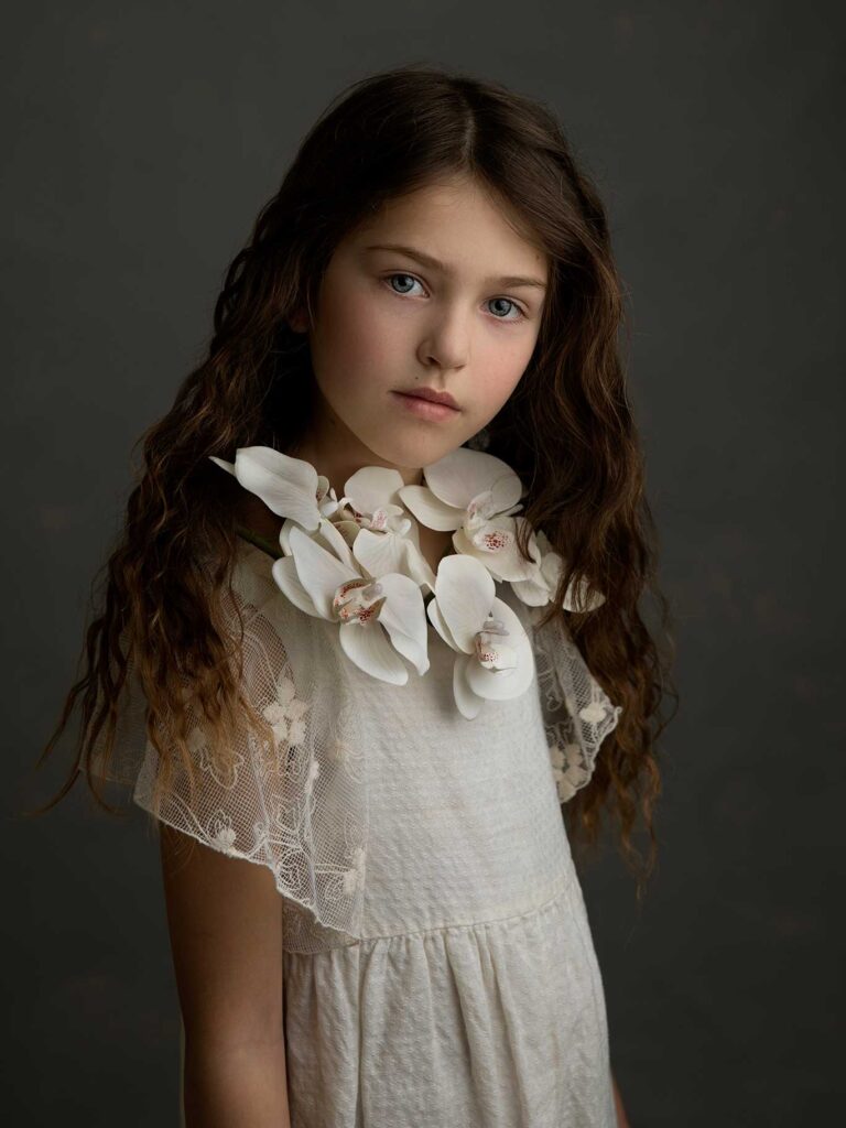 Konstnärligt barnporträtt på flicka med blommor i studio i Malmö.