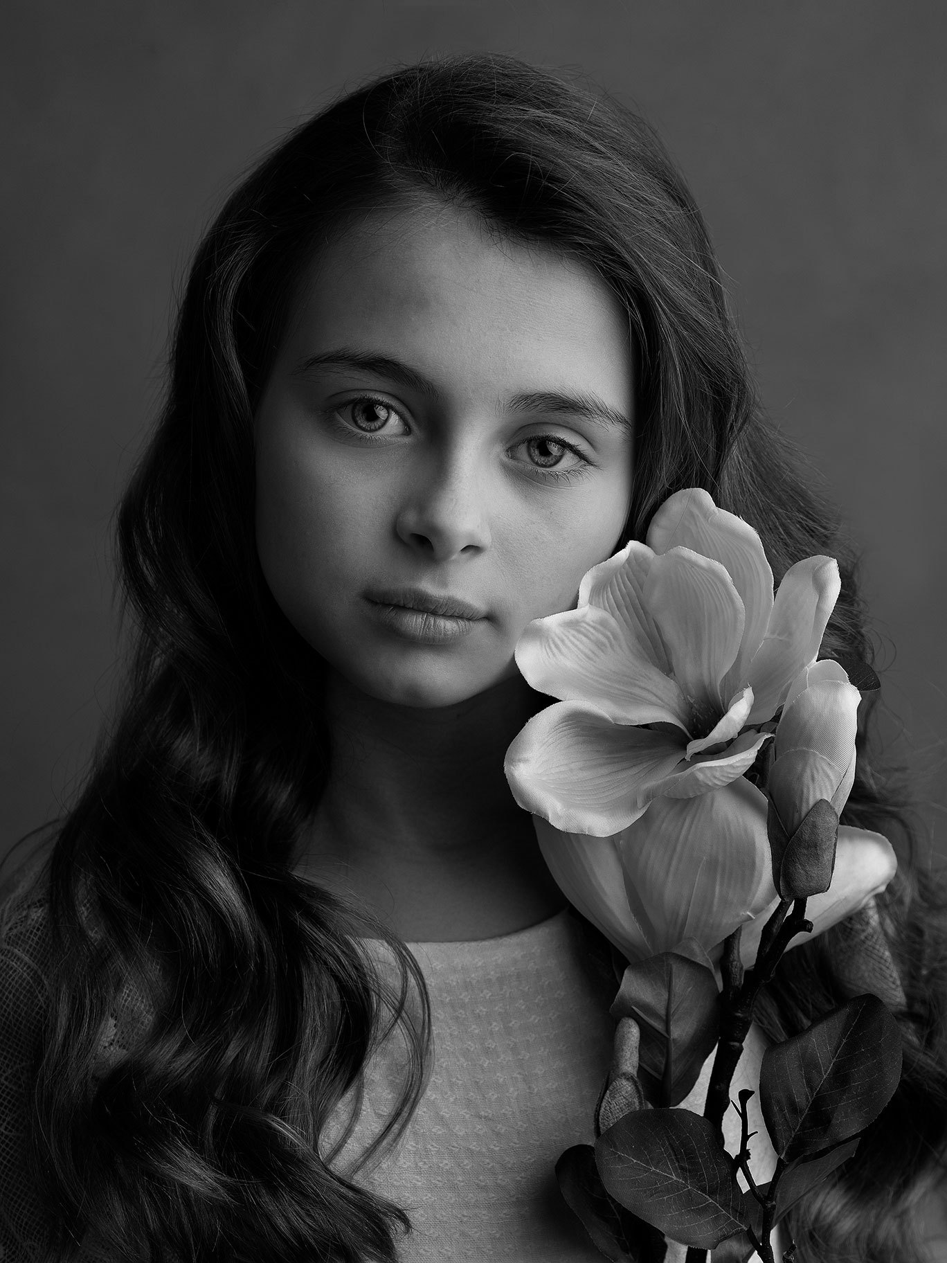 Vackert porträtt av barn i studiomiljö med varm ljussättning.