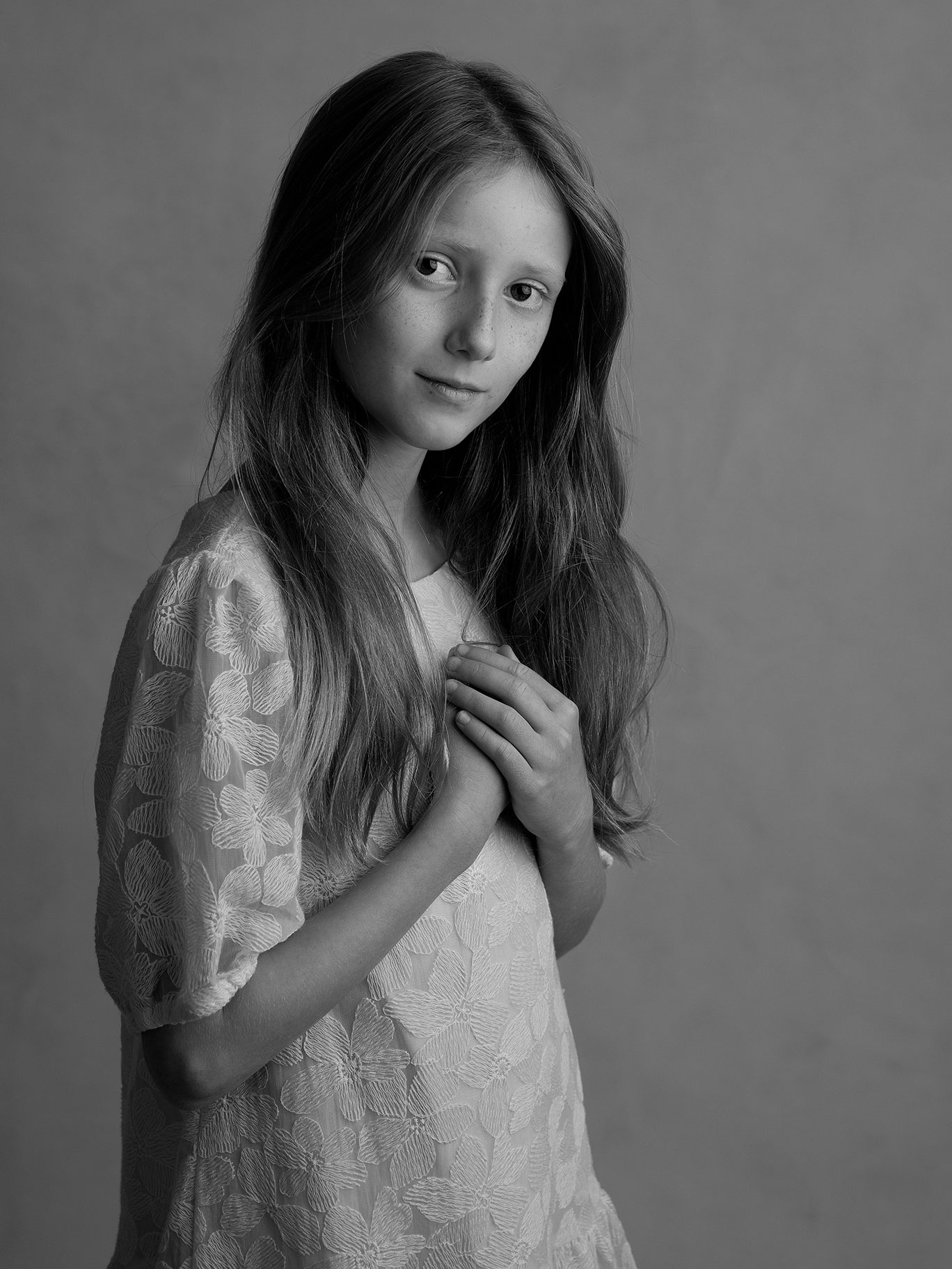 Konstnärlig bild av barn i naturlig pose med ljus bakgrund i studio.