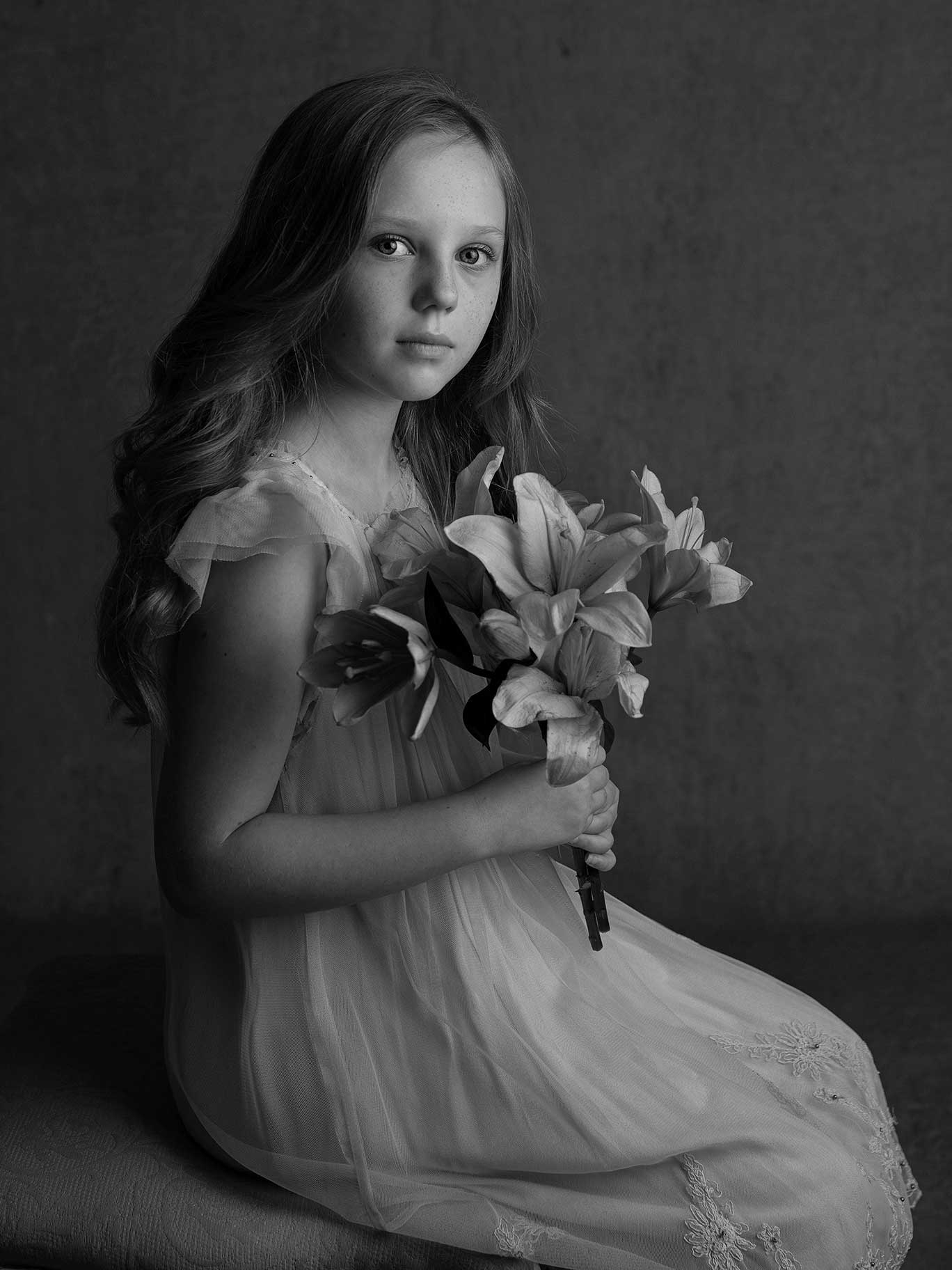 Porträtt som fångar barnets lugn och personlighet i konstnärlig studiomiljö.