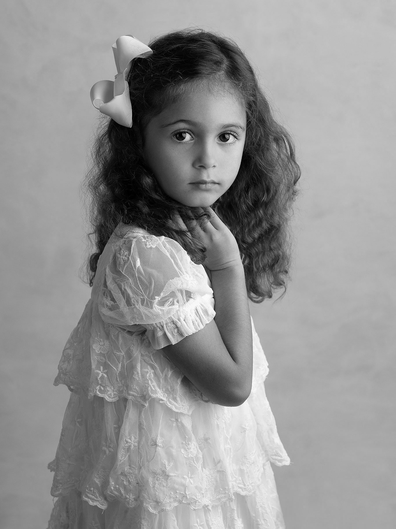 Flicka i söta kläder tittar stort mot kameran i studion hos Fotograf Anna Arvidsson i Malmö, Skåne.