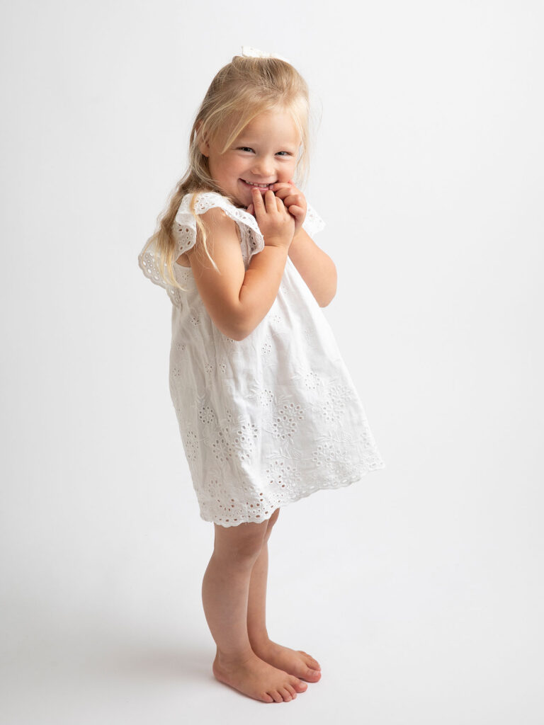 Flicka ler finurligt mot kameran hos Fotograf Anna Arvidsson i Malmö, Skåne.