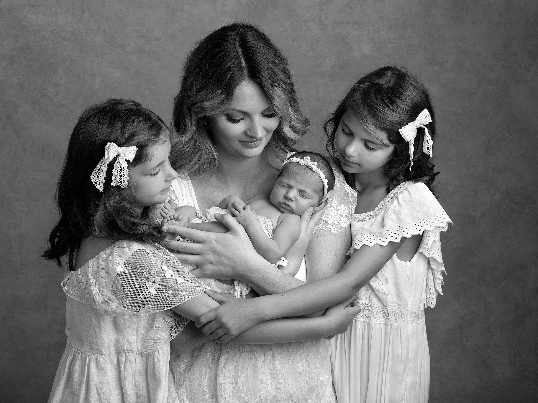 Mamma med nyfödd baby och sina andra två döttrar fotograferad i studion av barnfotograf Anna Arvidsson i Malmö.