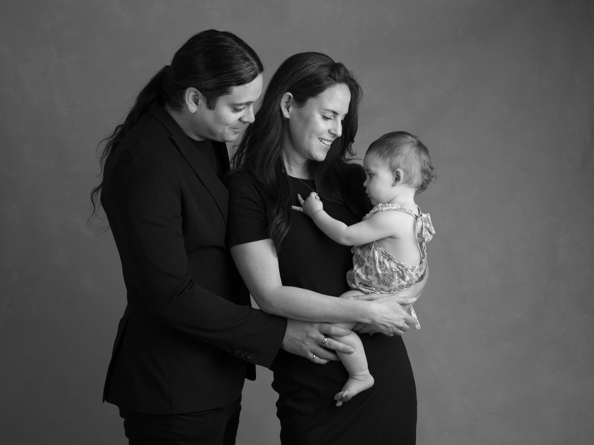 Föräldrar håller sitt barn i famnen under familjefotografering i Anna Arvidssons studio i Malmö.