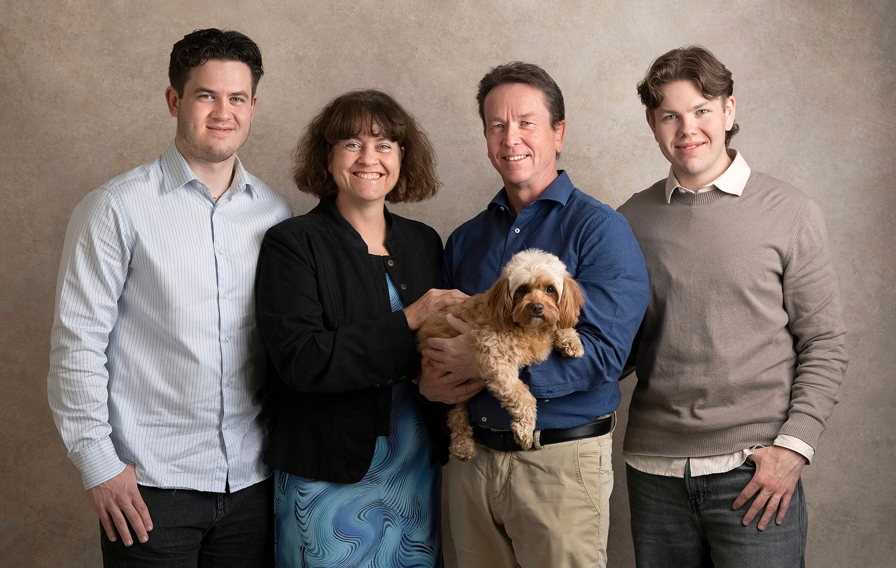 Familj poserar i mjukt ljus i Anna Arvidssons fotostudio i Skåne.