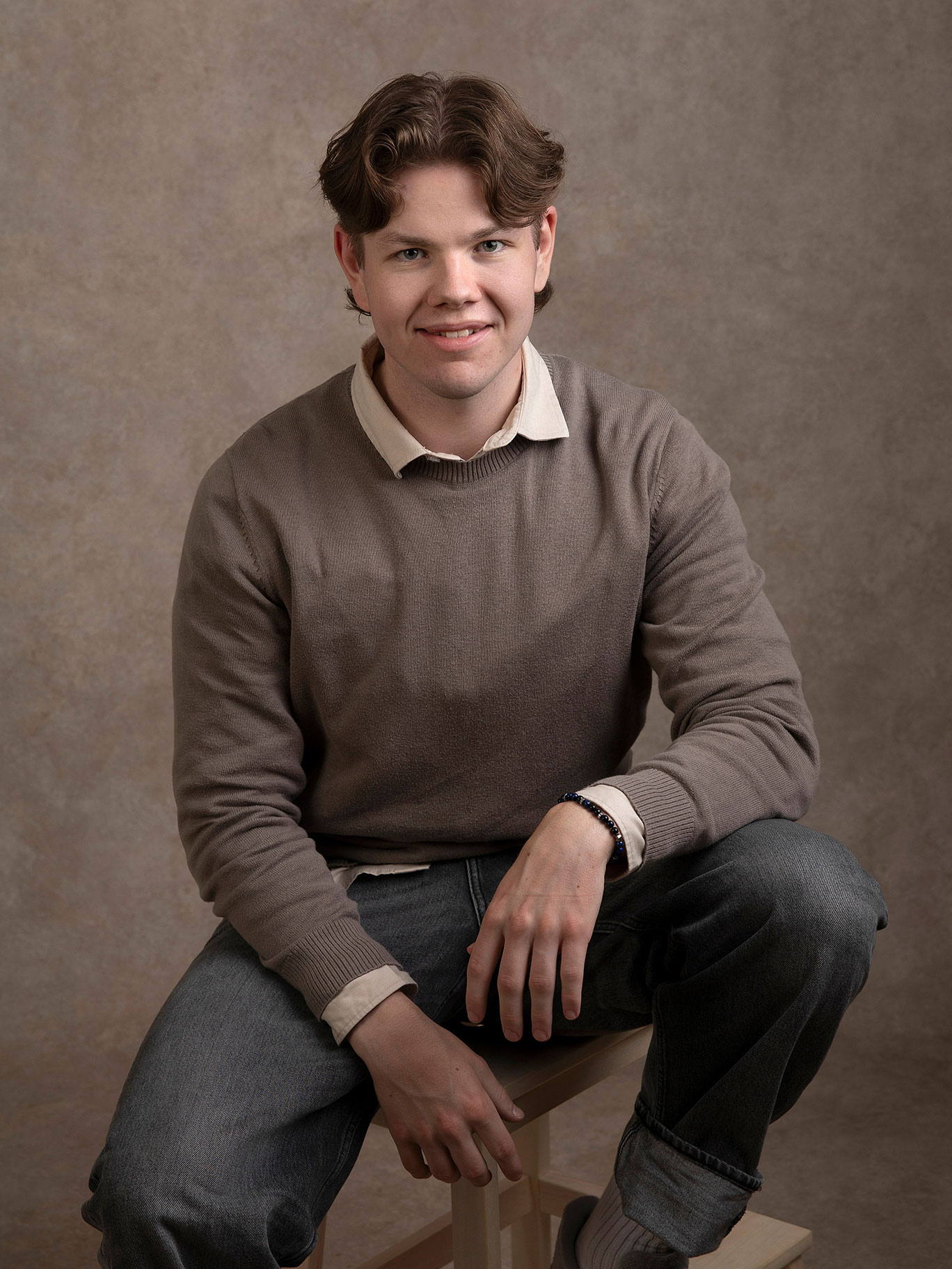 Kille sitter avslappnat under en fotografering i studio i Malmö.