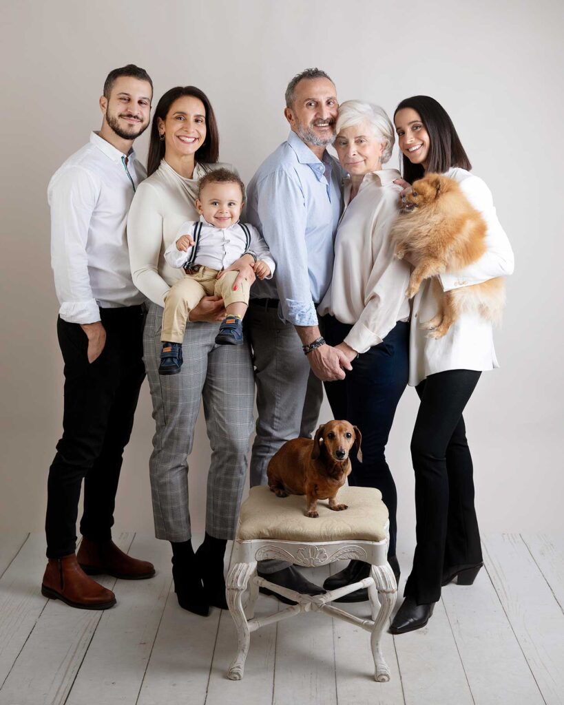 Stor familj med två hundar blir fotograferade i en studio i Malmö.