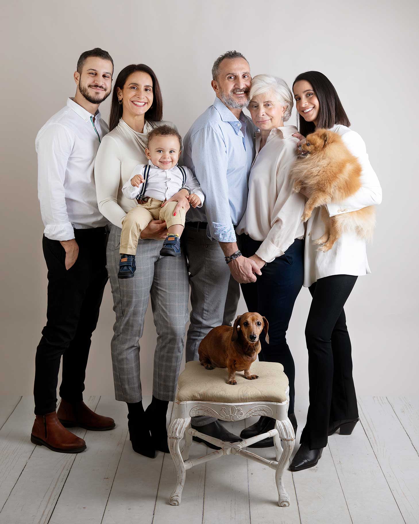 Stor familj med två hundar blir fotograferade i en studio i Malmö.