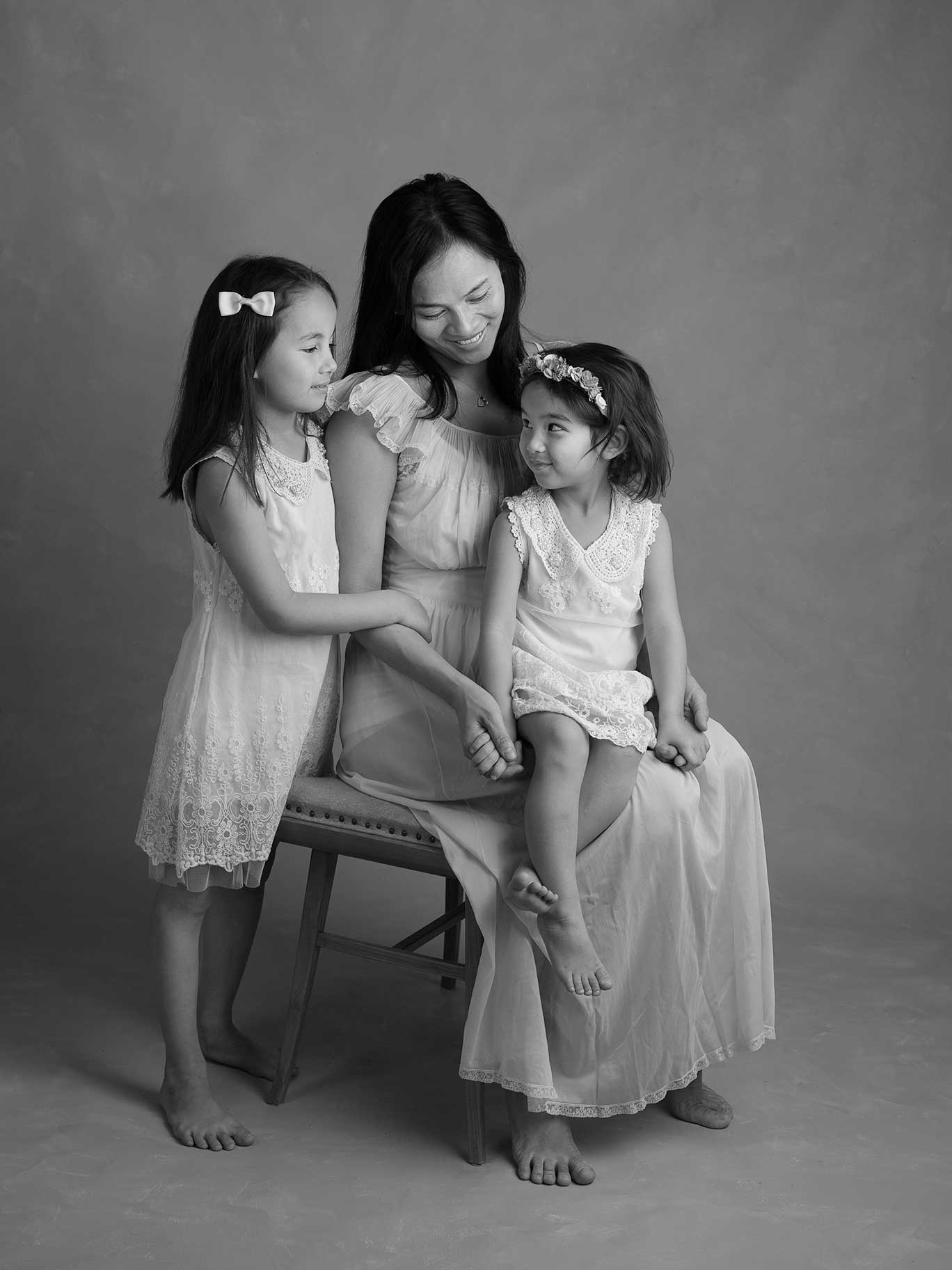 Mamma med två döttrar under familjefotografering hos Fotograf Anna Arvidsson.