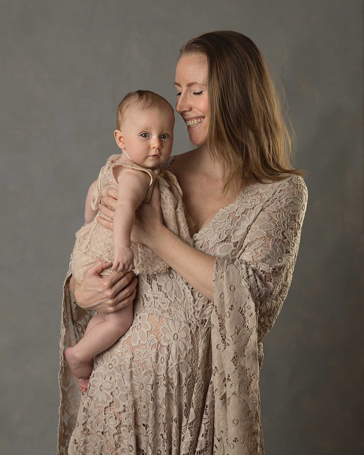 Mamma busar med sin baby i en fotostudio i Skåne.