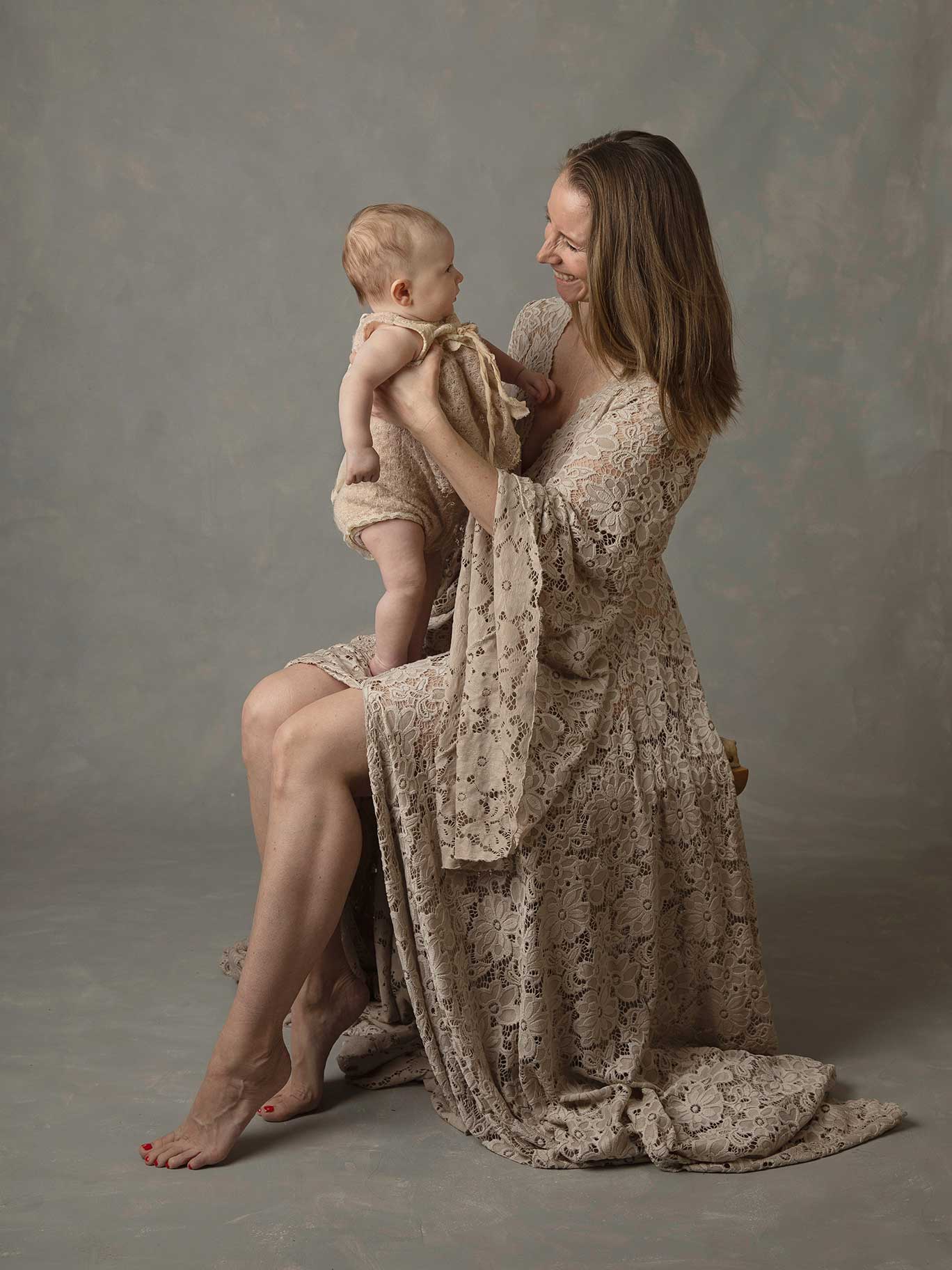 Mamma skojar med sin baby i en fotostudio i Malmö.