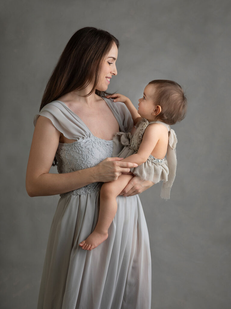 Porträttfotografering i Malmö med mamma och baby som tittar på varandra i fina blå klänningar.