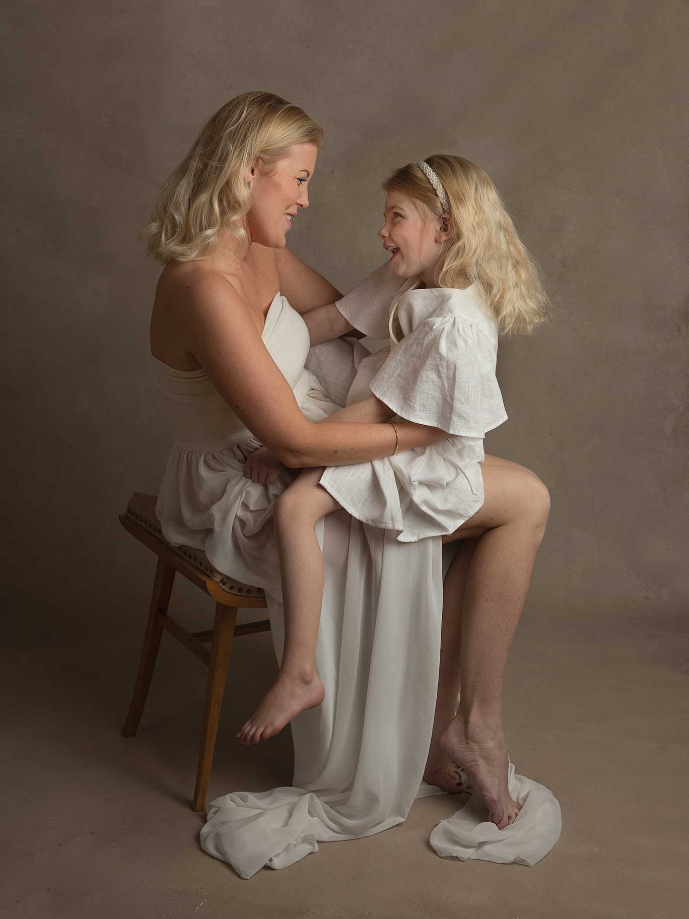 En mamma busar med sin lilla dotter under en fotografering.