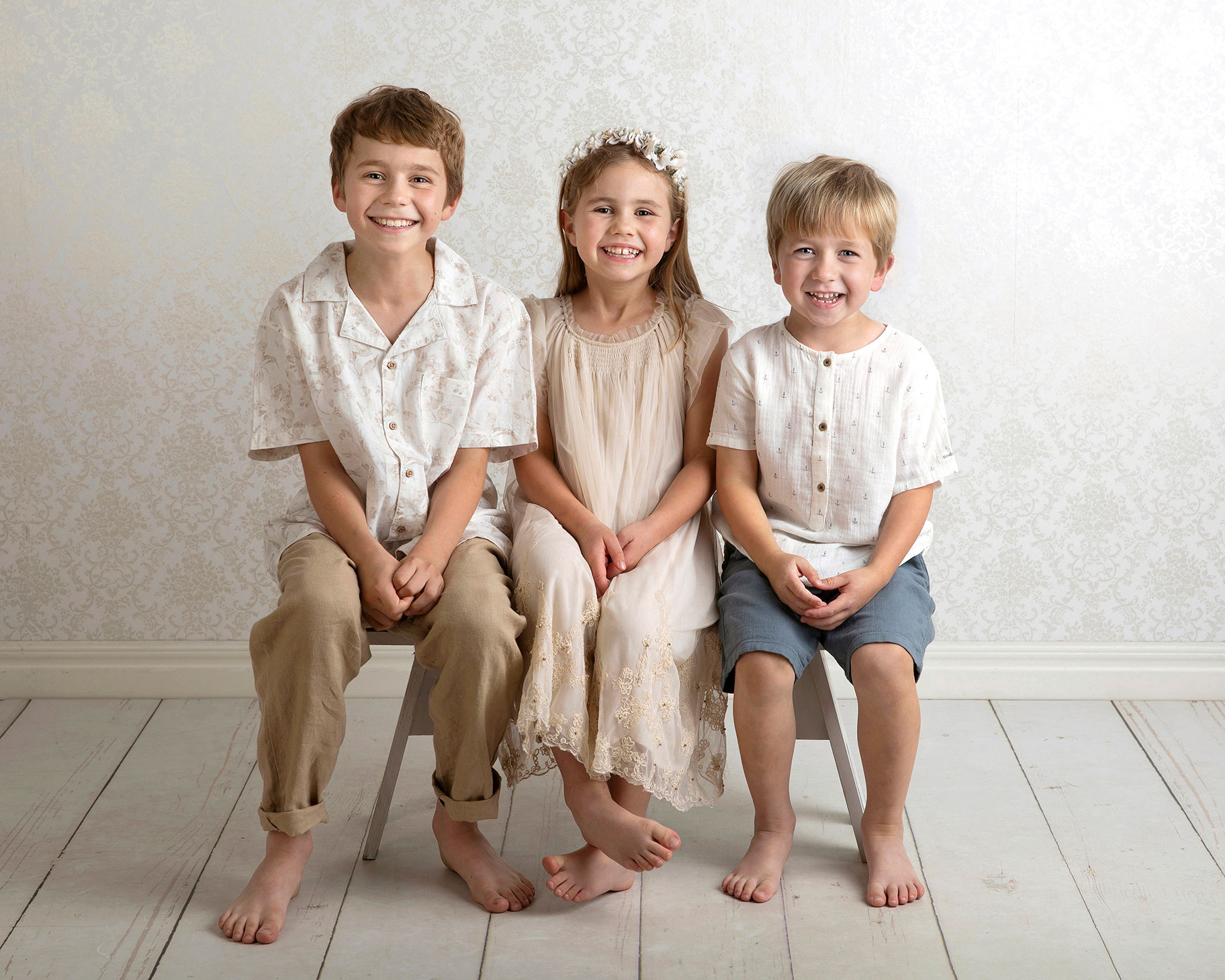 Tre syskon tittar fint mot kameran, fotograferat av Anna Arvidsson i Skåne.