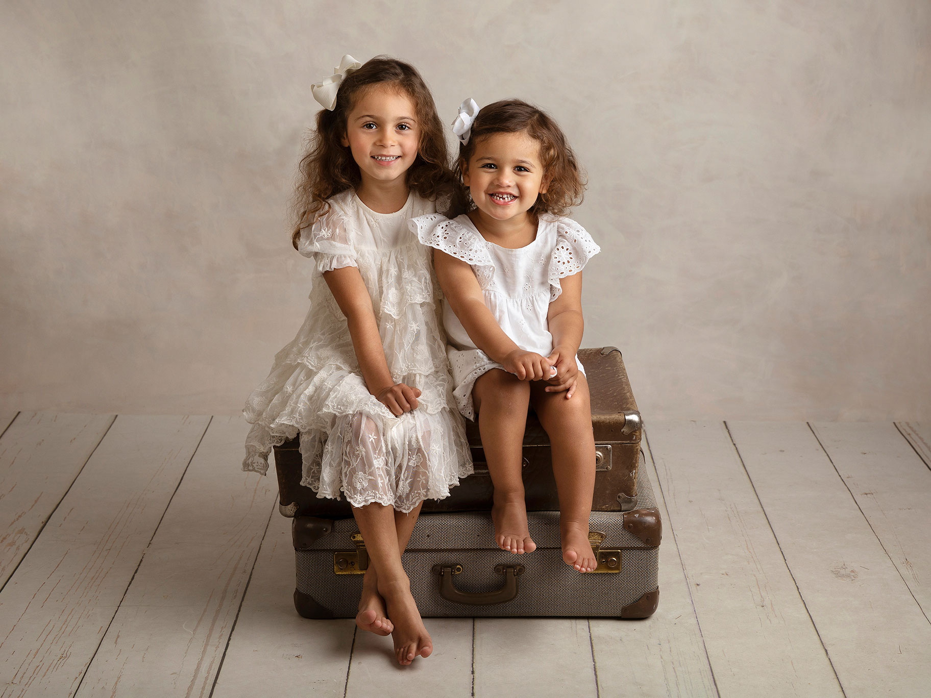 Två systrar i vita klänningar blir fotograferade i studion i Malmö av fotograf Anna Arvidsson.