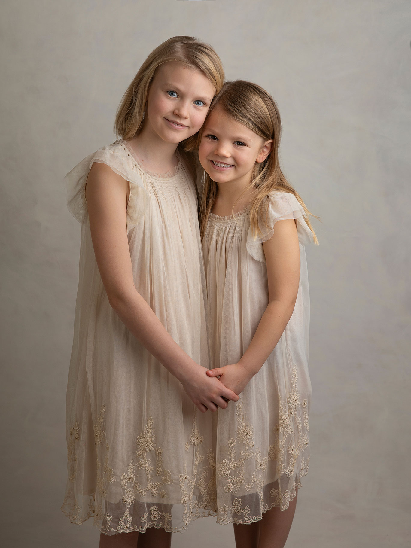 Två systrar håller hand och blir fotograferade av fotograf Anna Arvidsson i studion i Malmö.