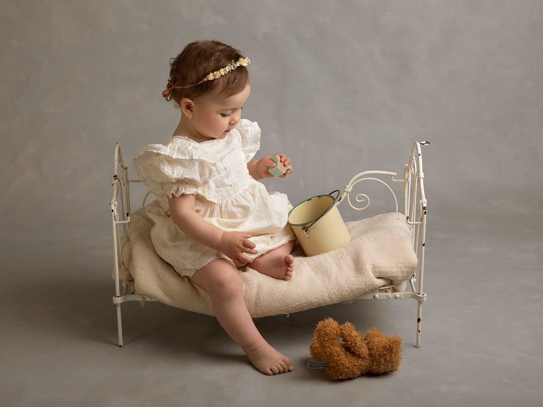 Baby sitter på säng och leker när Anna Arvidsson fotograferar henne i Malmö.