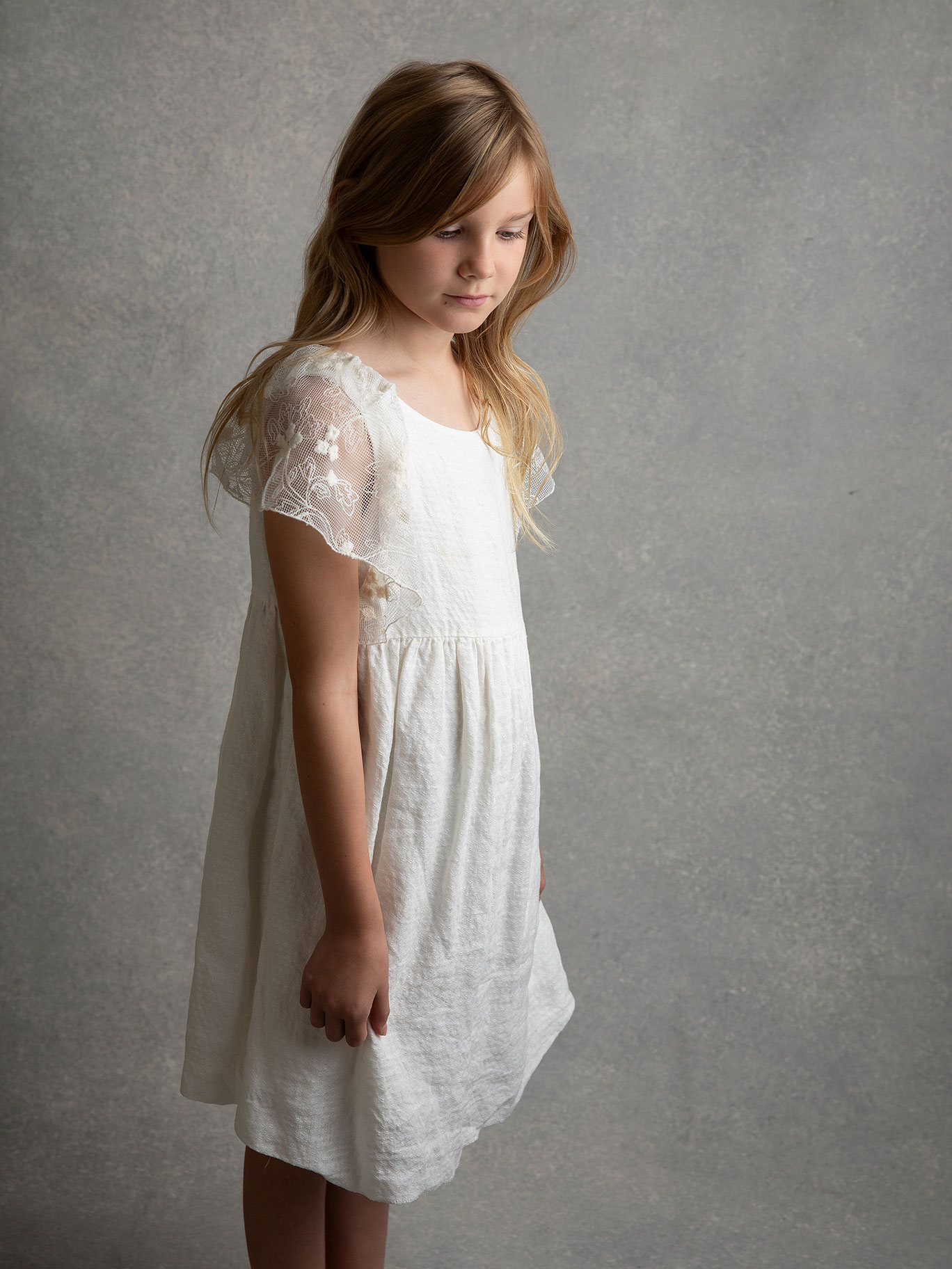 Malmöflicka i skolåldern tittar ner när hon blir fotograferad.