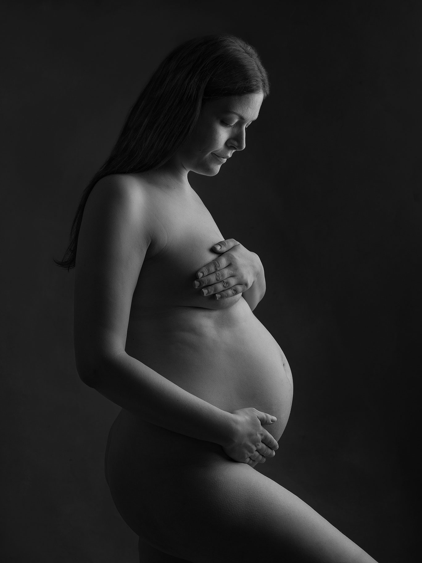 Konstnärligt porträtt i svartvitt av gravid kvinna tagen i studio i Malmö.