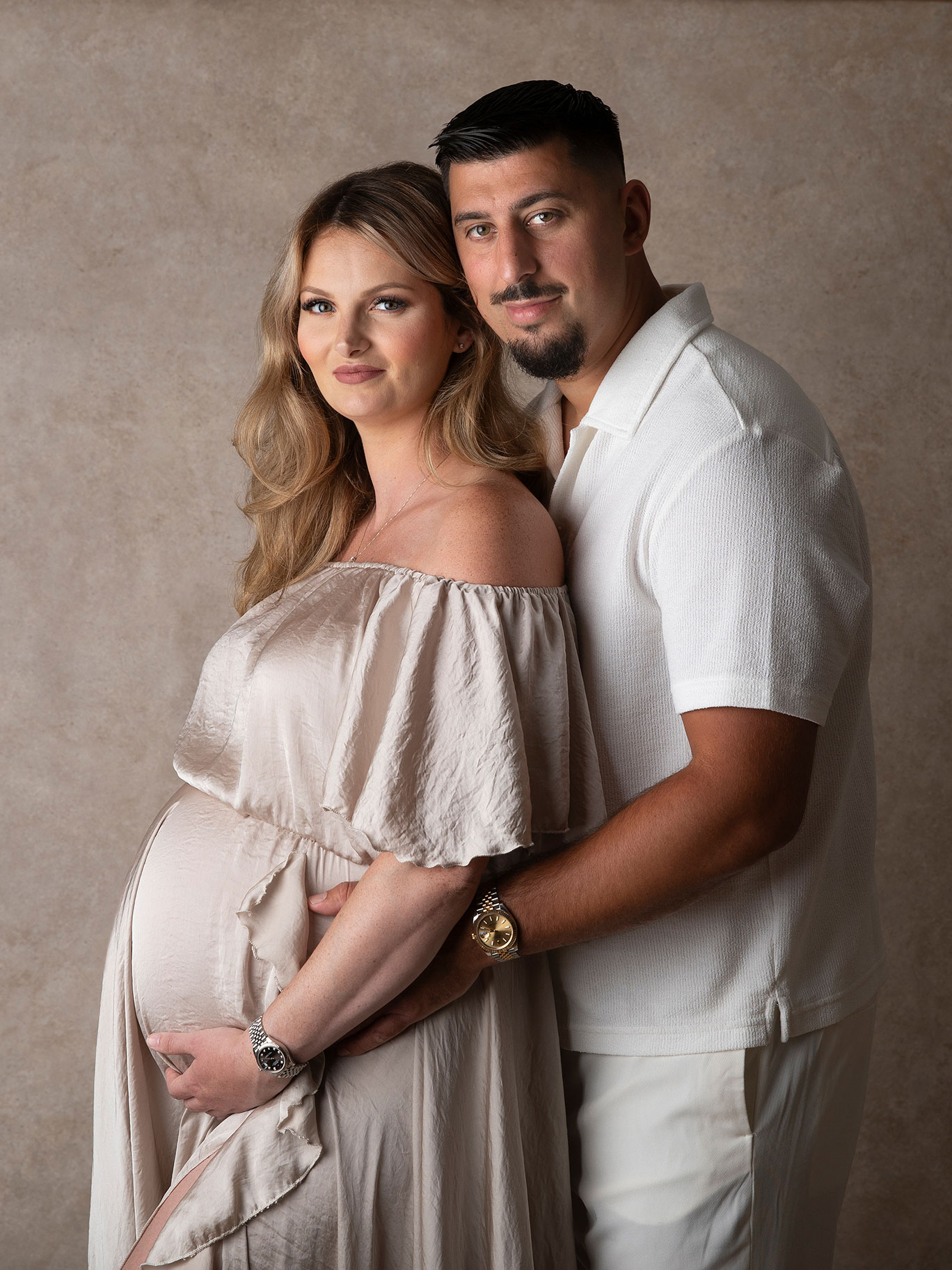 Blivande föräldrar håller om varandra under gravidfotografering i Skåne.