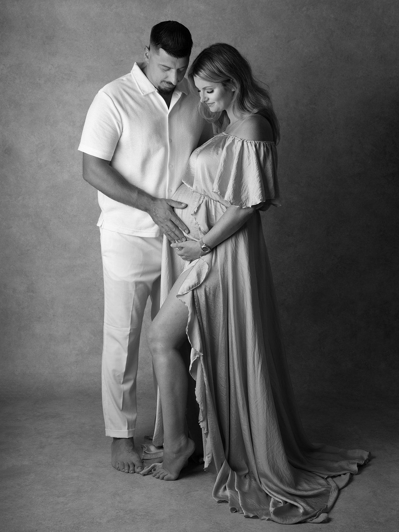 Blivande föräldrar håller om varandra under gravidfotografering i Malmö.