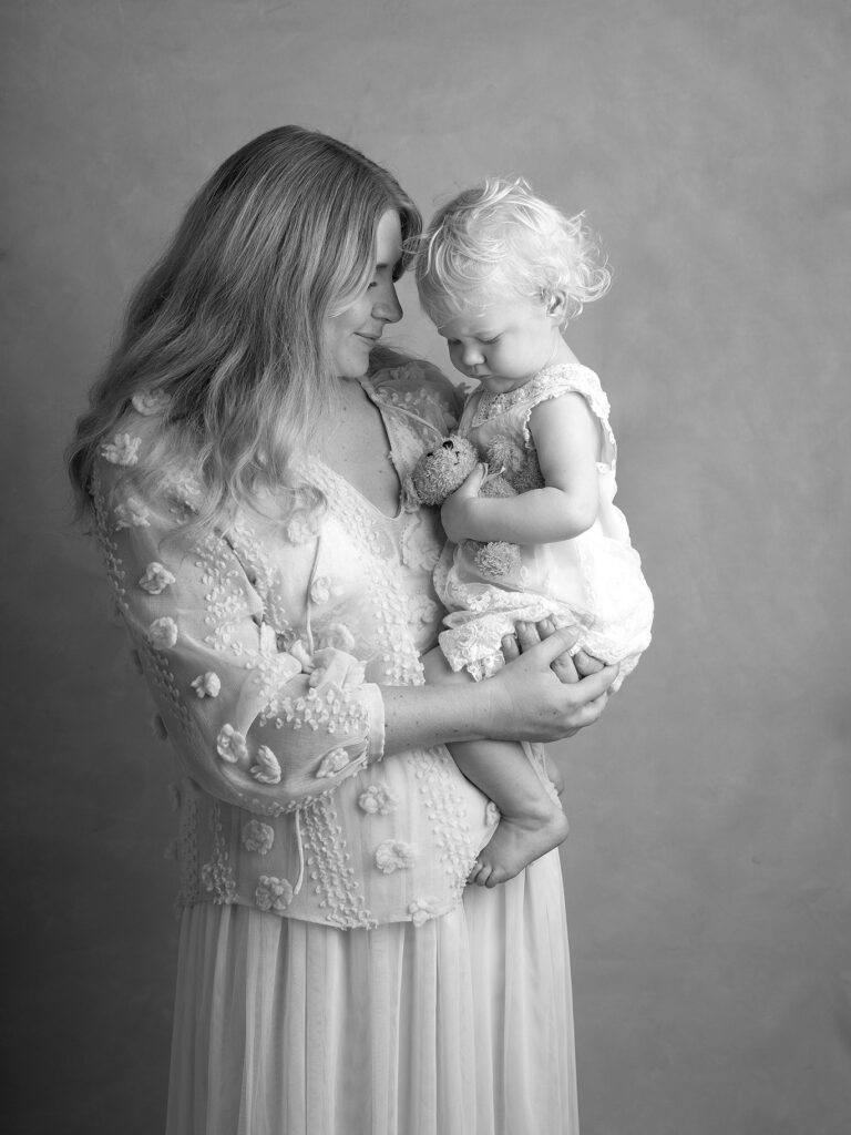 Mamma tittar på sin baby i en fotostudio i Malmö.