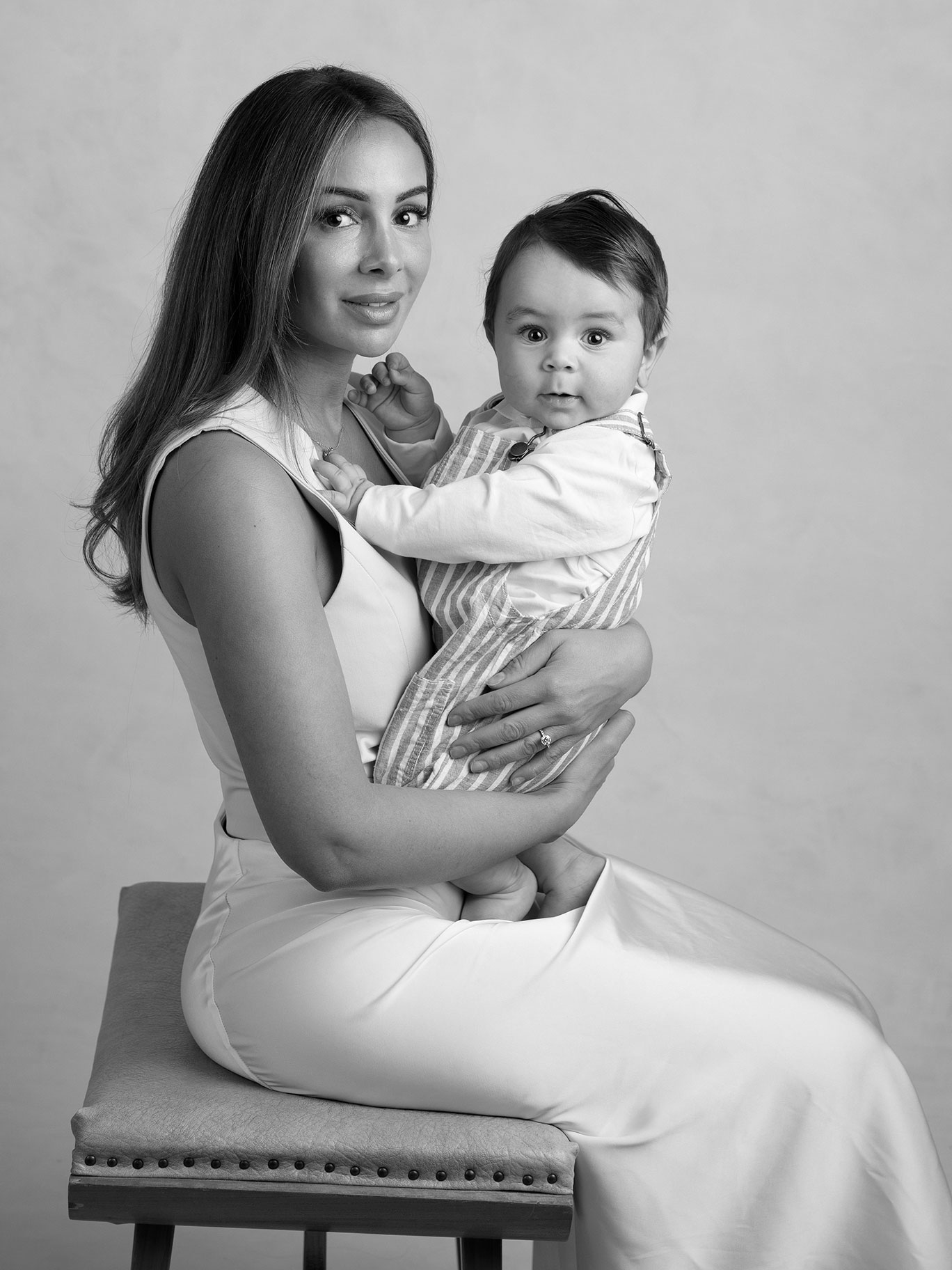Mamma håller om sin baby i en fotostudio i Malmö.