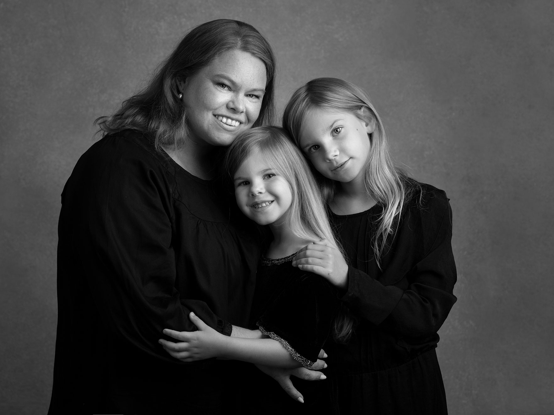 En vacker mamma med två döttrar blir fotograferade i en studio i Malmö, Skåne.