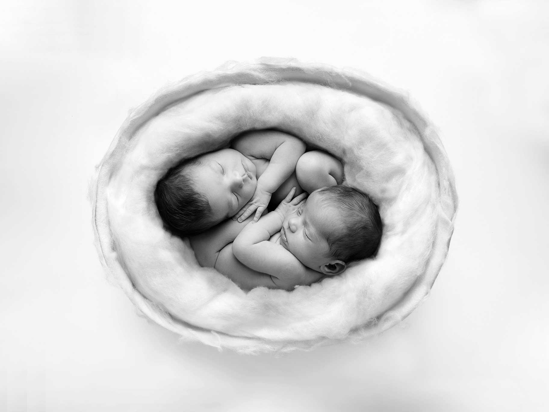 Nyfödda tvillingar i en liten korg, fotograferade av nyföddfotograf Anna Arvidsson i Malmö.