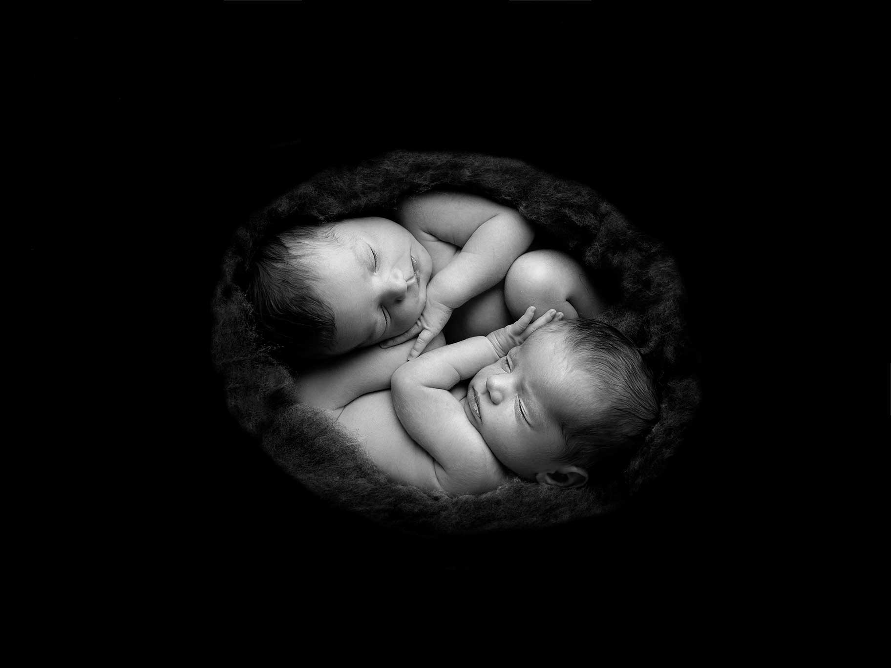 Nyfödda tvillingar i en liten korg.