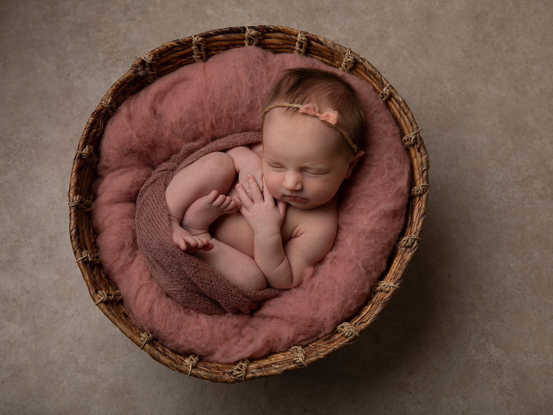 Nyfödd flicka i korg fotograferad när hon sover hos en barnfotograf i Malmö.