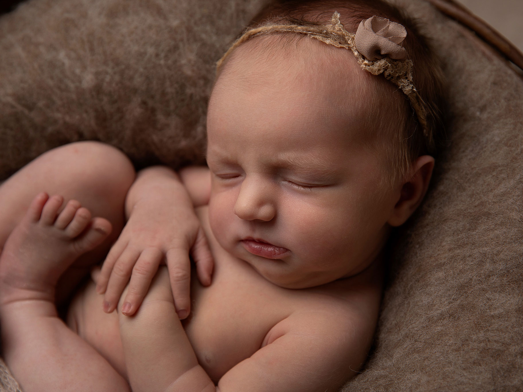 Nyfödd flicka i korg fotograferad när hon sover hos en barnfotograf i Malmö.