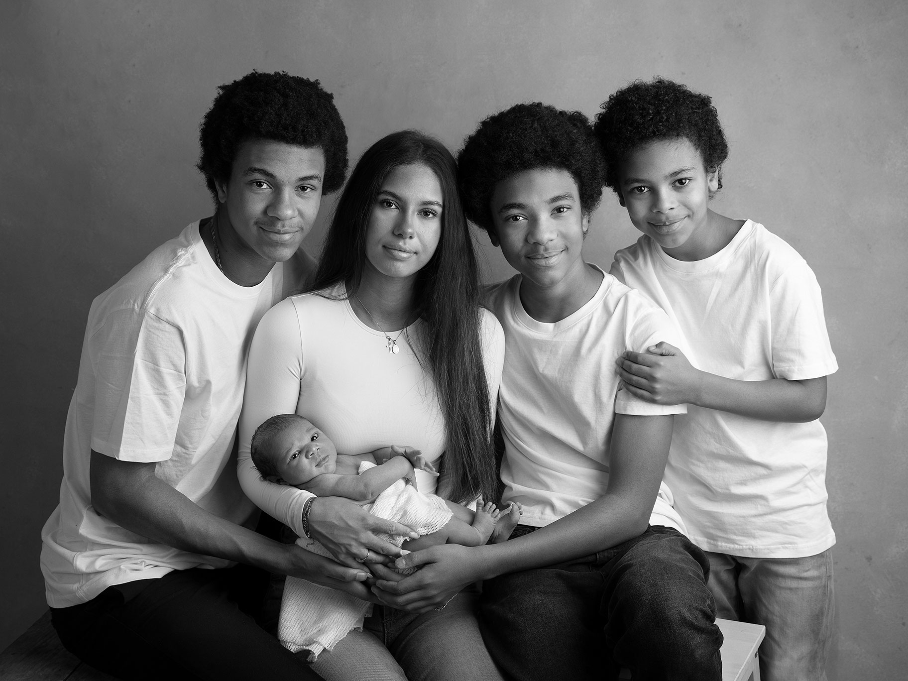 Stor syskonskara som håller sin lilla nyfödda lillebror, bild tagen av Fotograf Anna Arvidsson i Malmö.