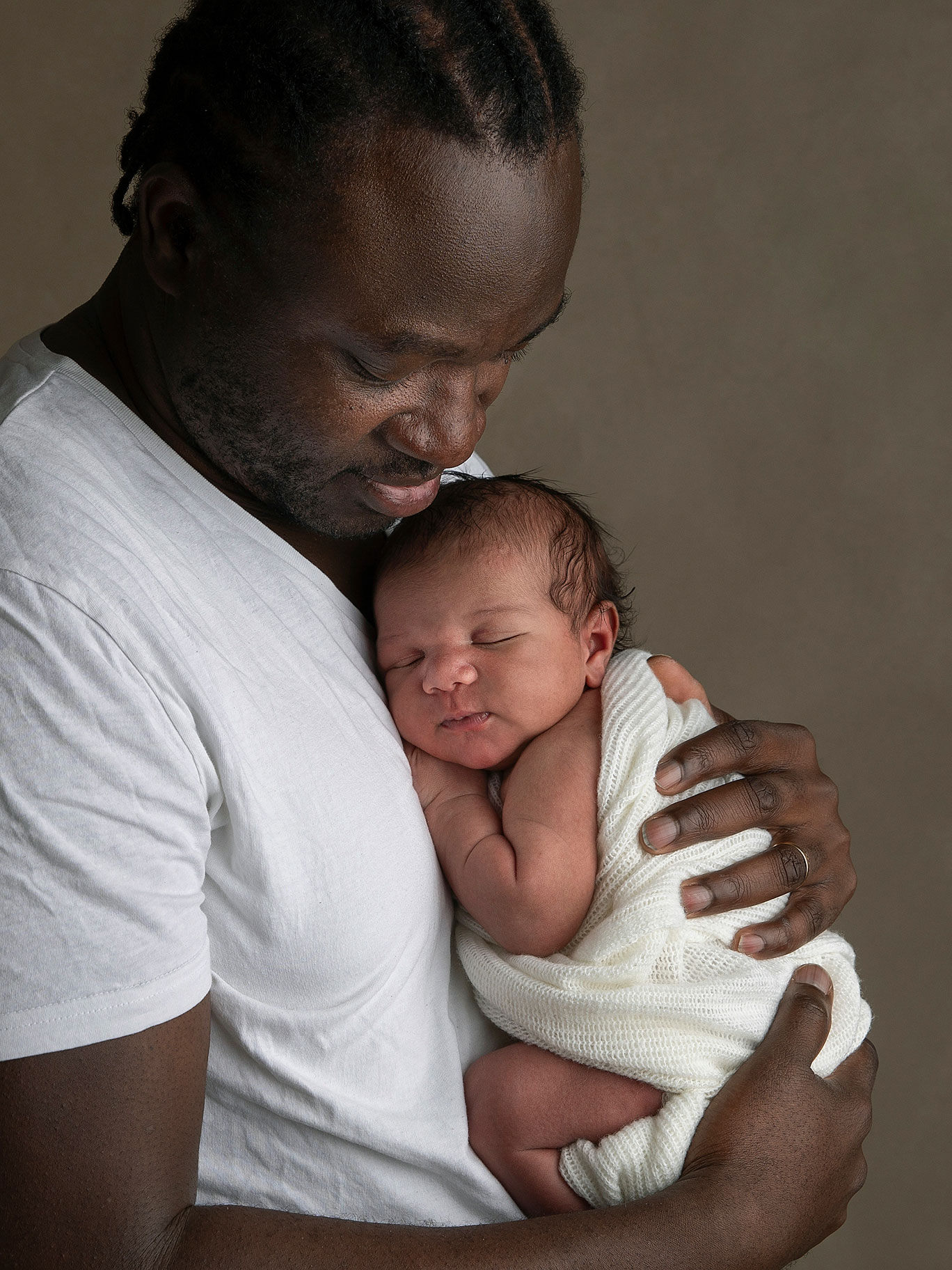 Pappa med sin nyfödda baby i sina händer, bild av Fotograf Anna Arvidsson , familjefotograf i Malmö.