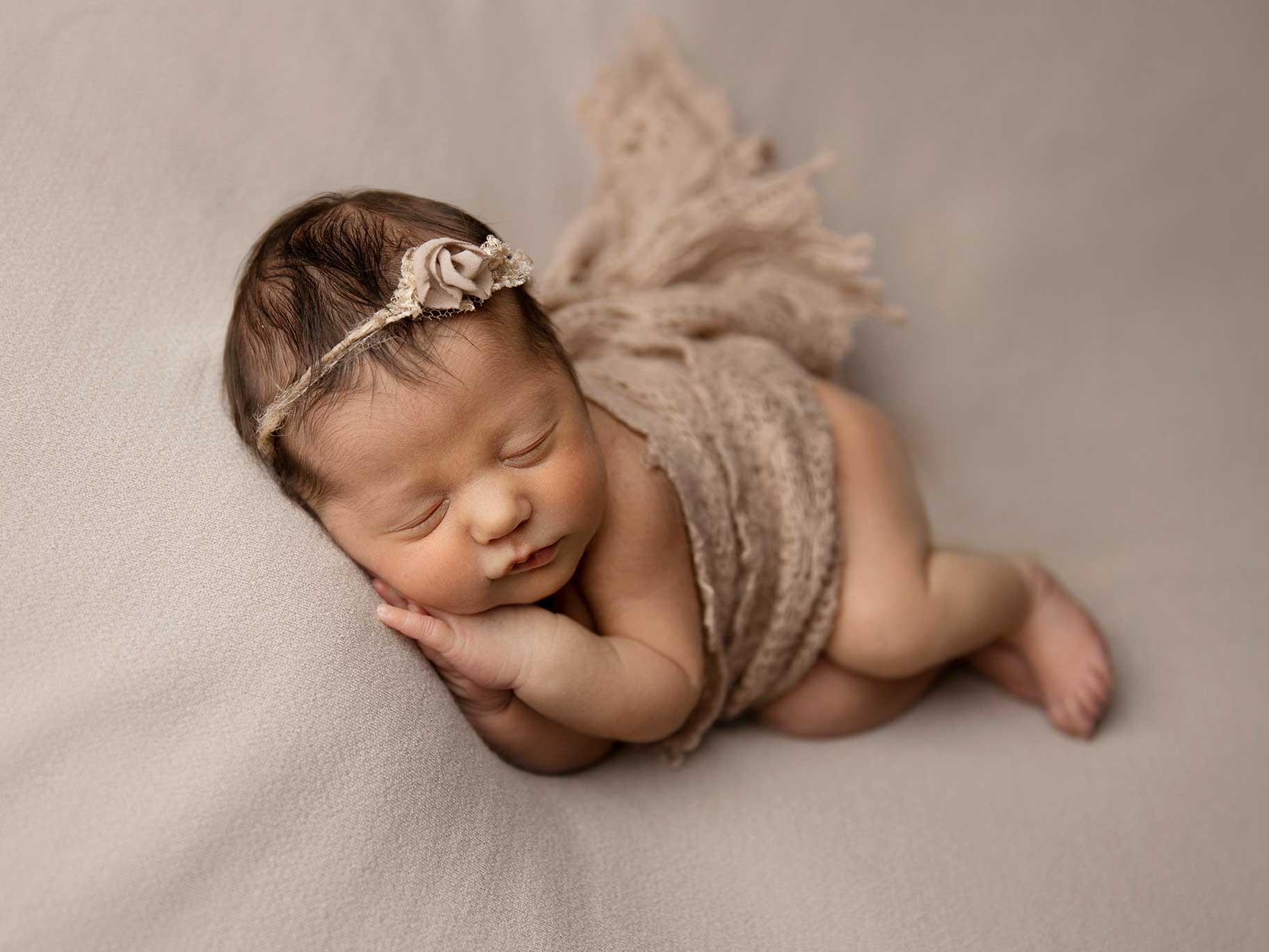 Nyfödd flicka ligger ner på filt fotograferad när hon bara är 1 vecka gammal.