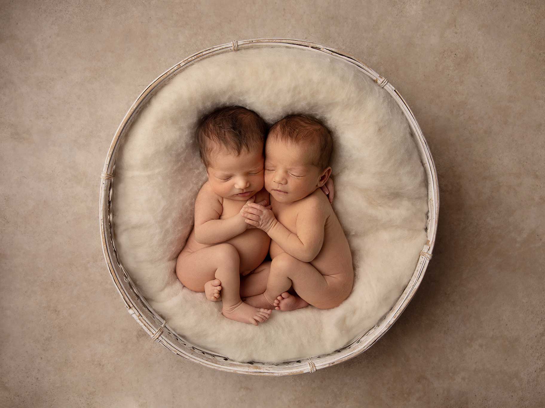 Nyfödda tvillingar i en liten korg, fotograferade av nyföddfotograf Anna Arvidsson i Malmö.