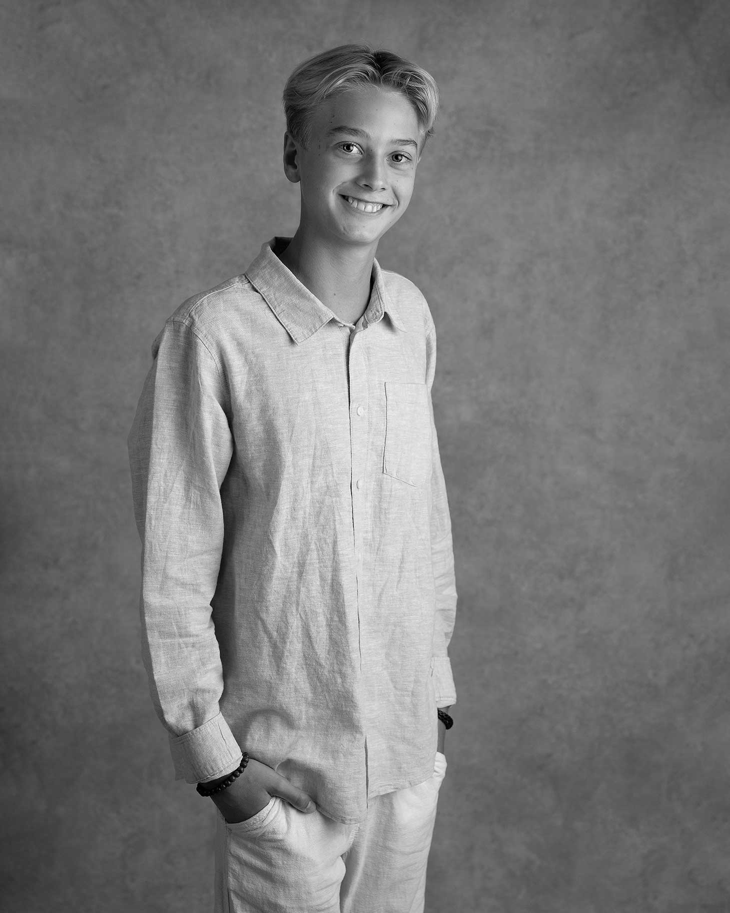 Ung kille står med händerna i fickorna.